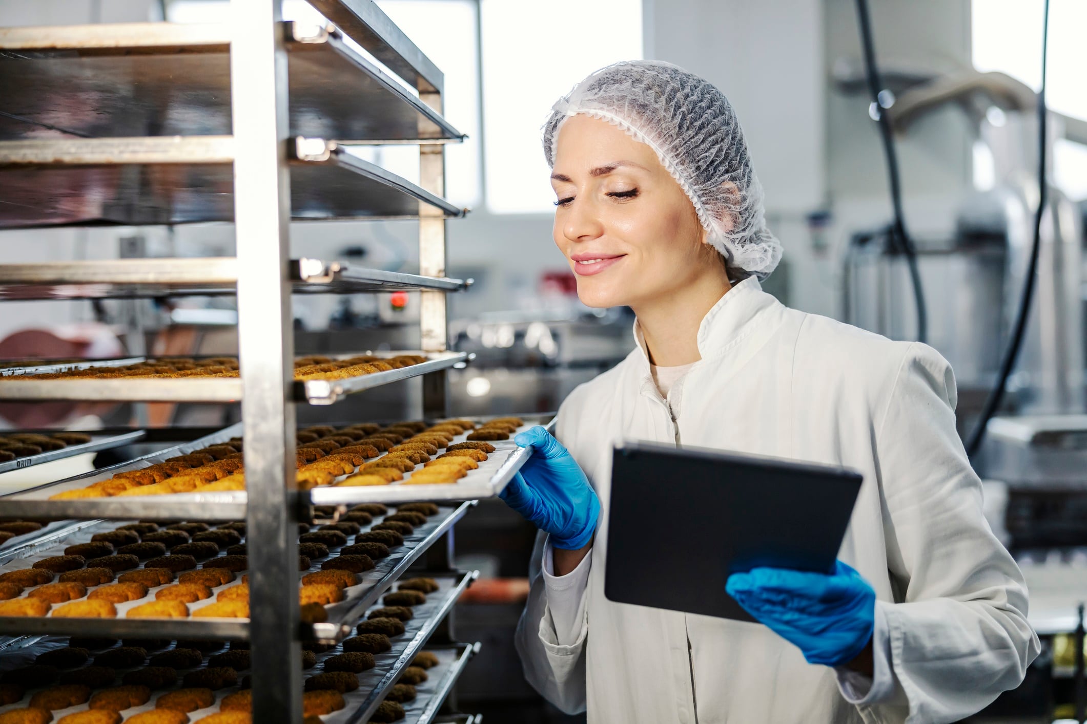 Female bakery factory worker inspecting product