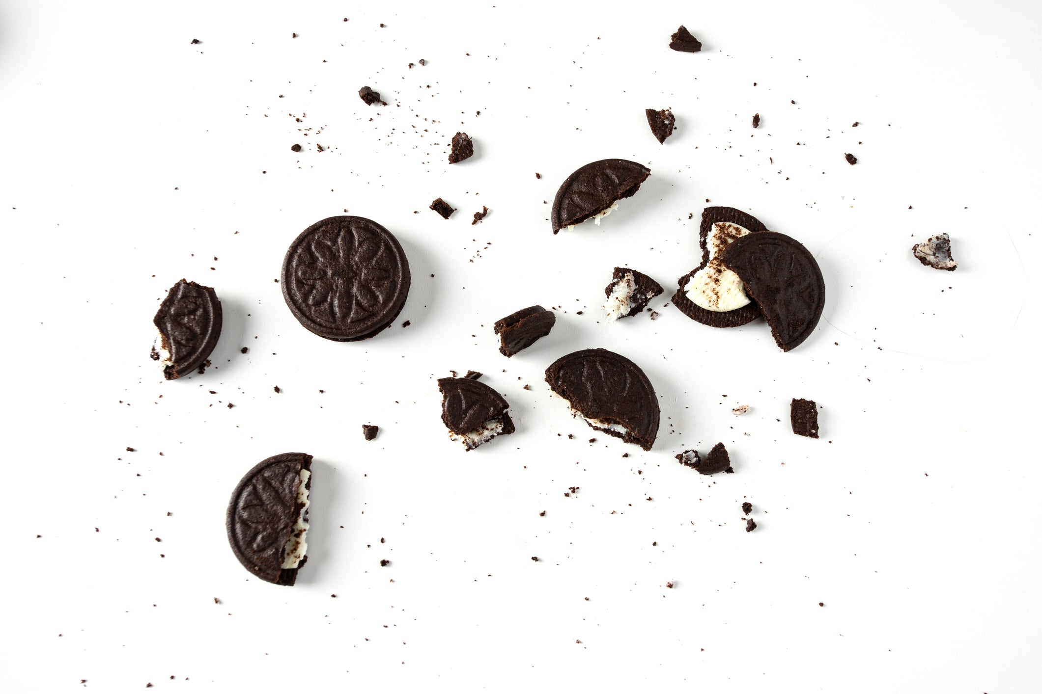 Mondelez International is taking Aldi to court over its copycat packaging. Top view of broken sandwich chocolate cookies with milky cream on white background.