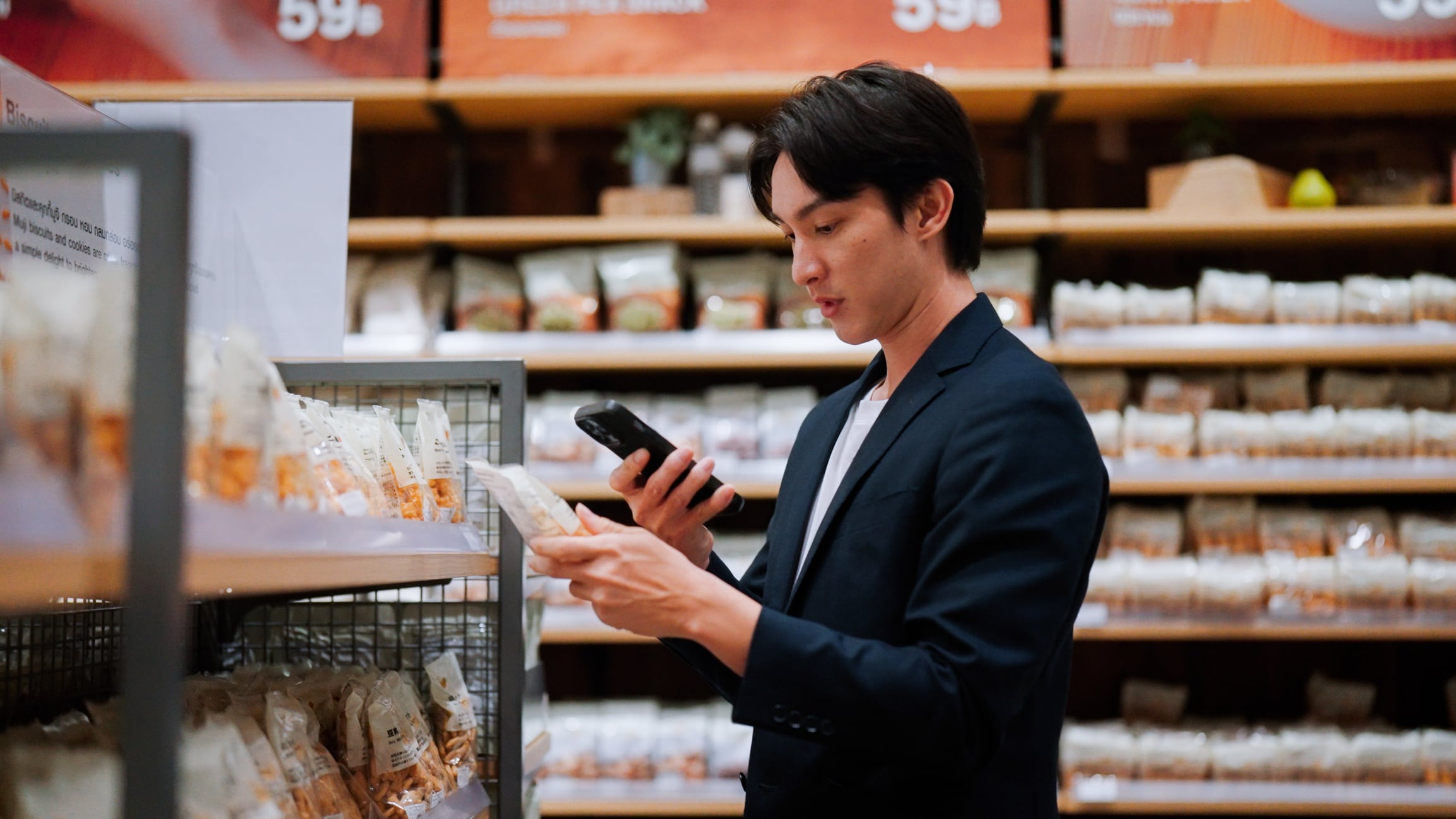 Young Asian man using smartphone to scan QR code