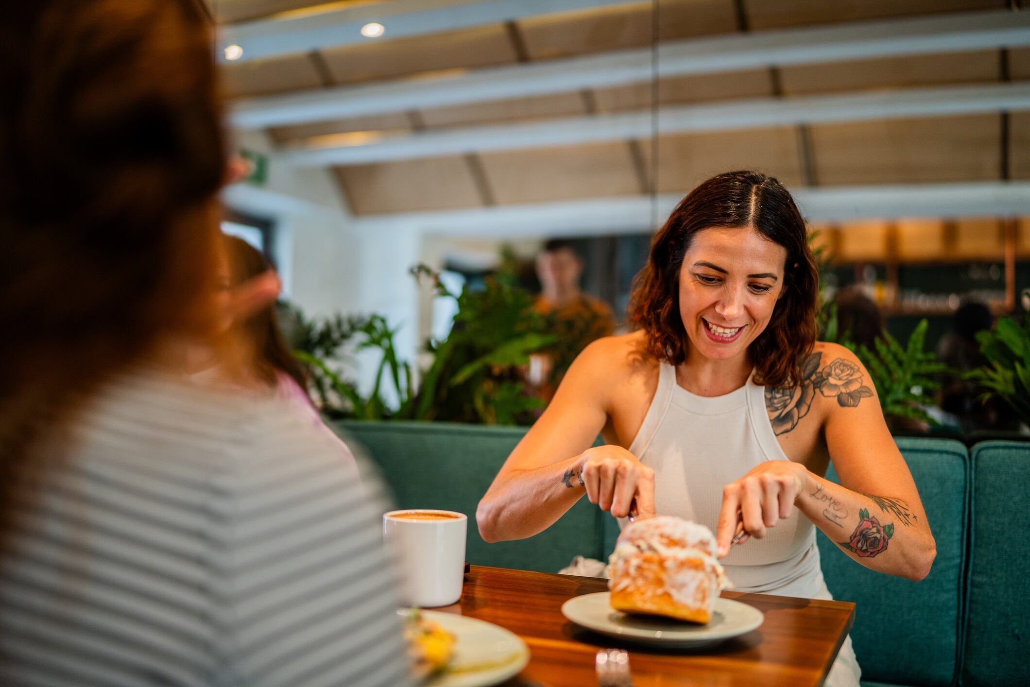 Mid adult woman talking with friend in breakfast at coffee shop FG Trade Latin - GettyImages