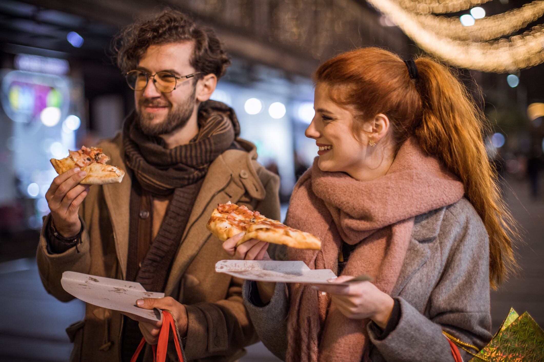 Couple eating pizza on the go