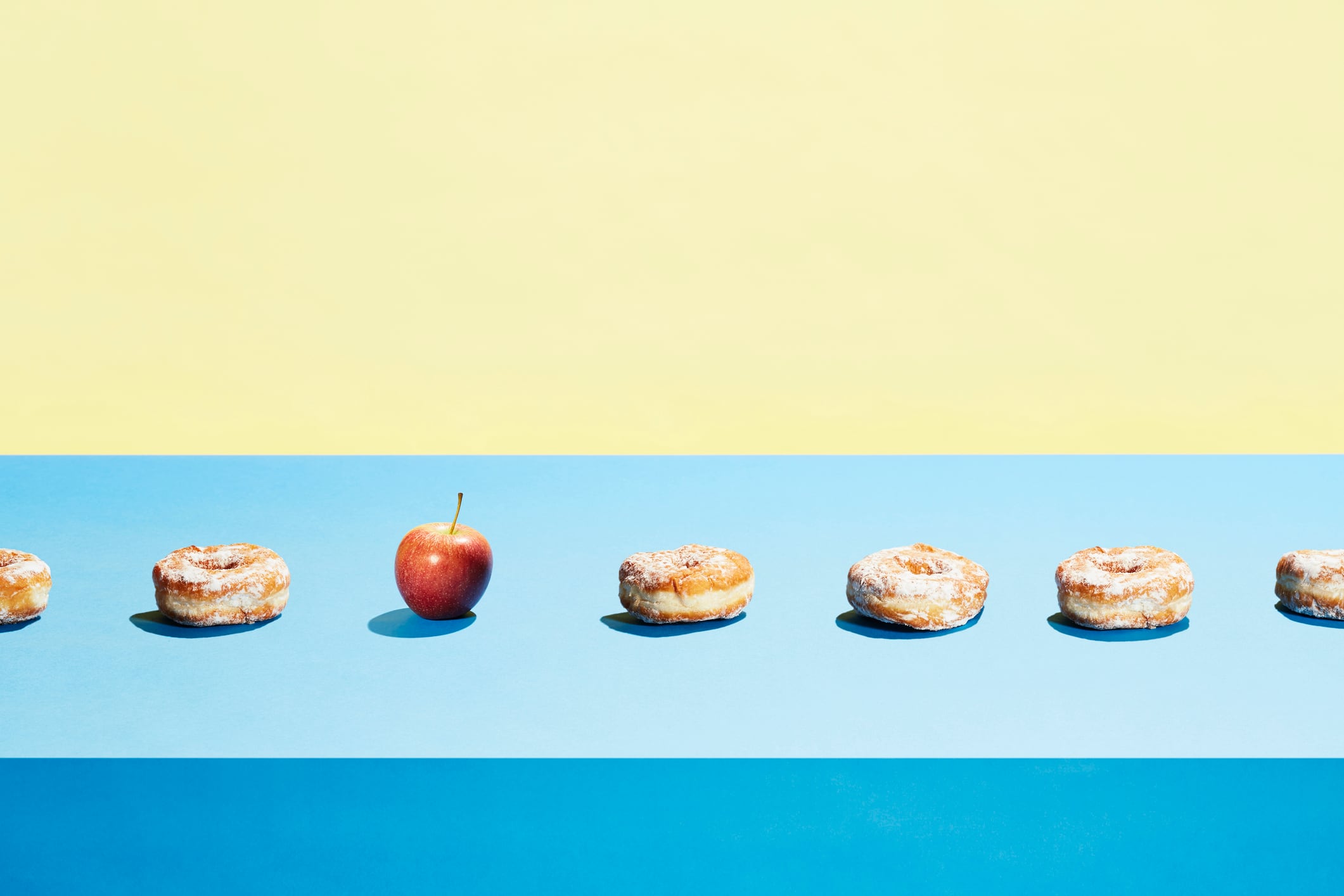 A row of doughnuts including an apple