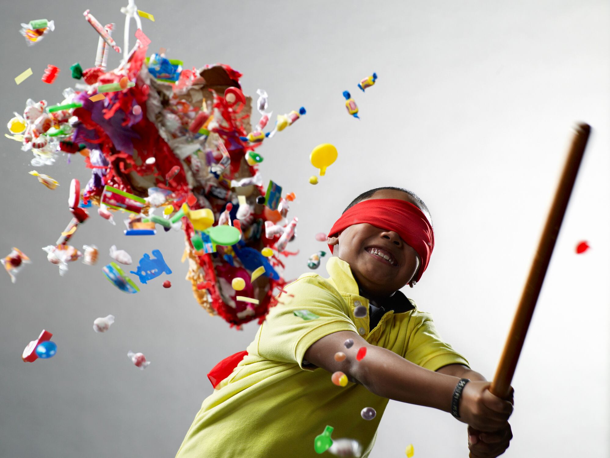 Image: boy hitting sweets from a toy