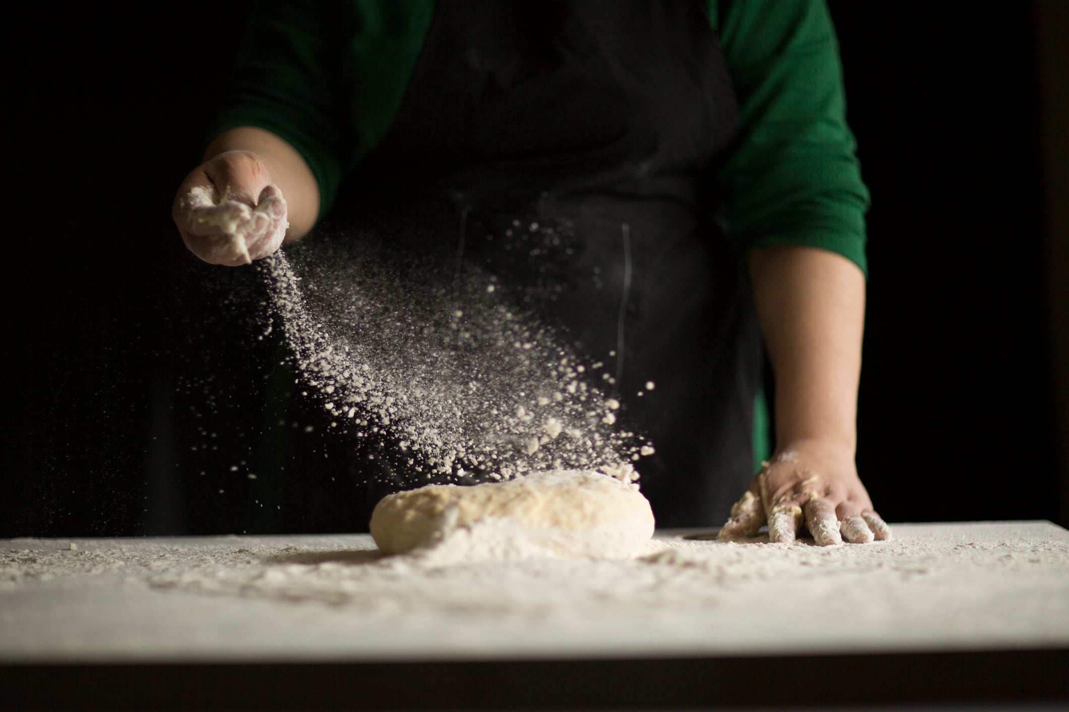 Baker kneading a loaf with flour ridvan_celik GettyImages