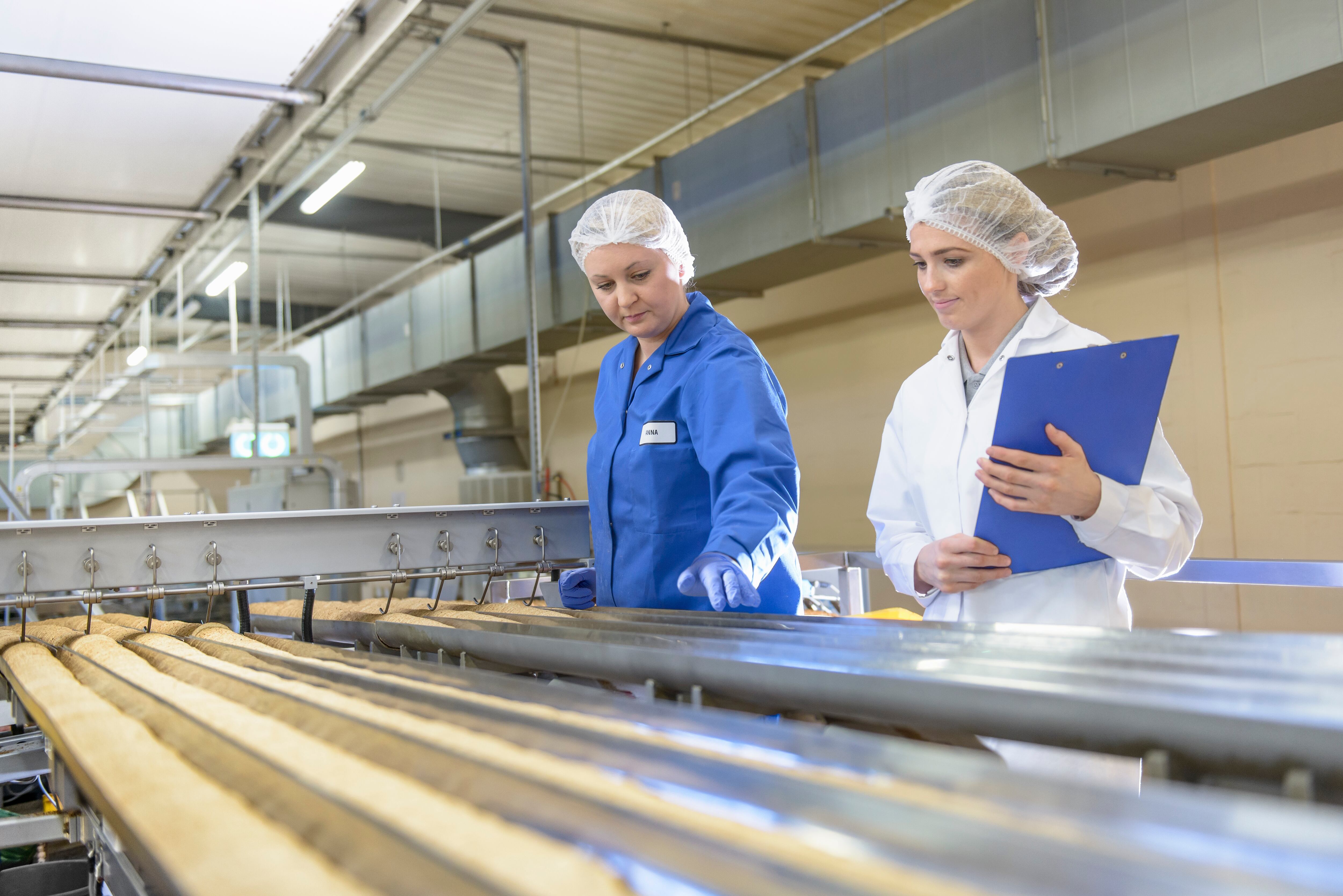 Workers inspecting biscuits on a production line