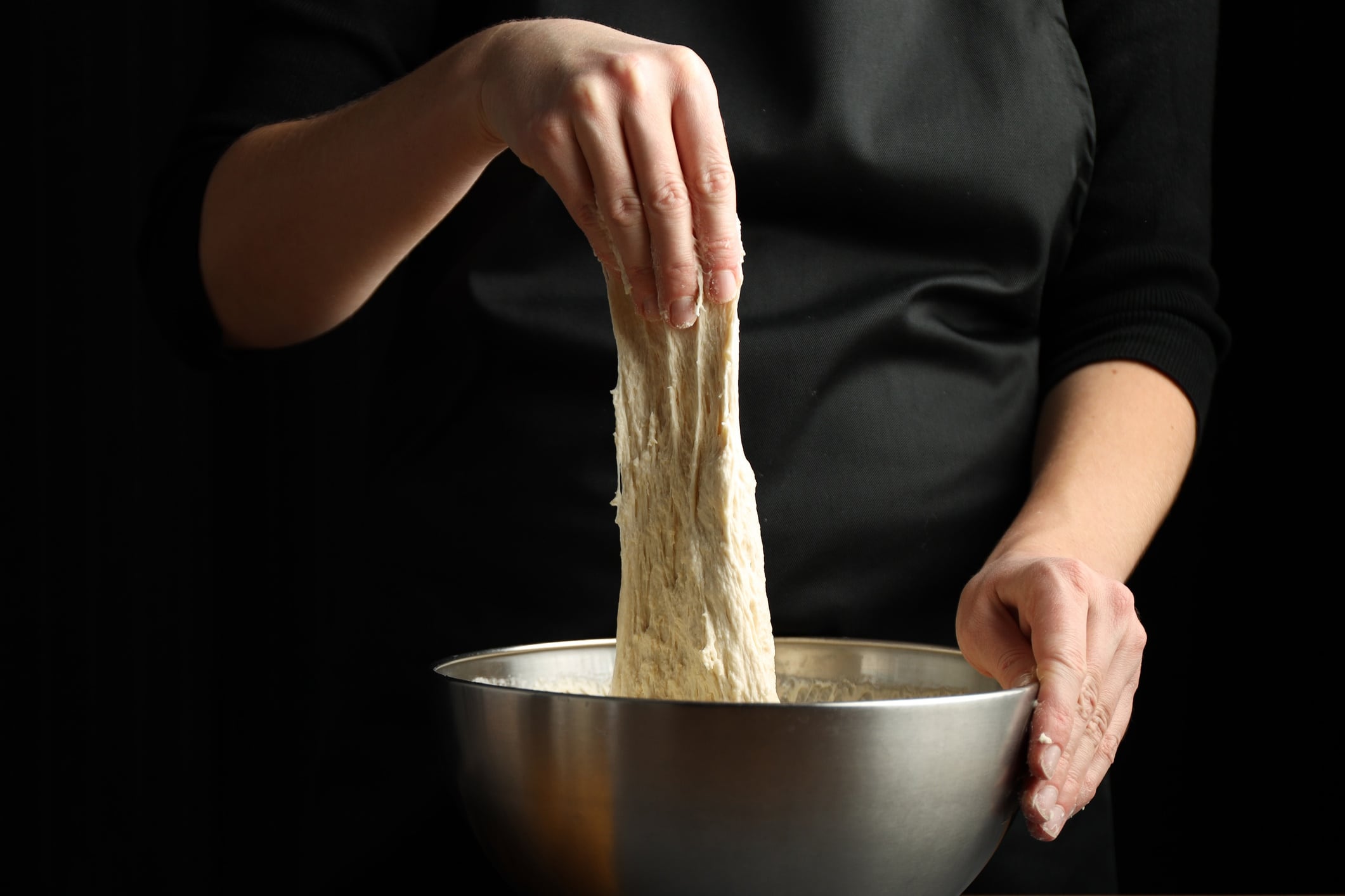 Woman cook stretches yeast dough, sourdough for bread