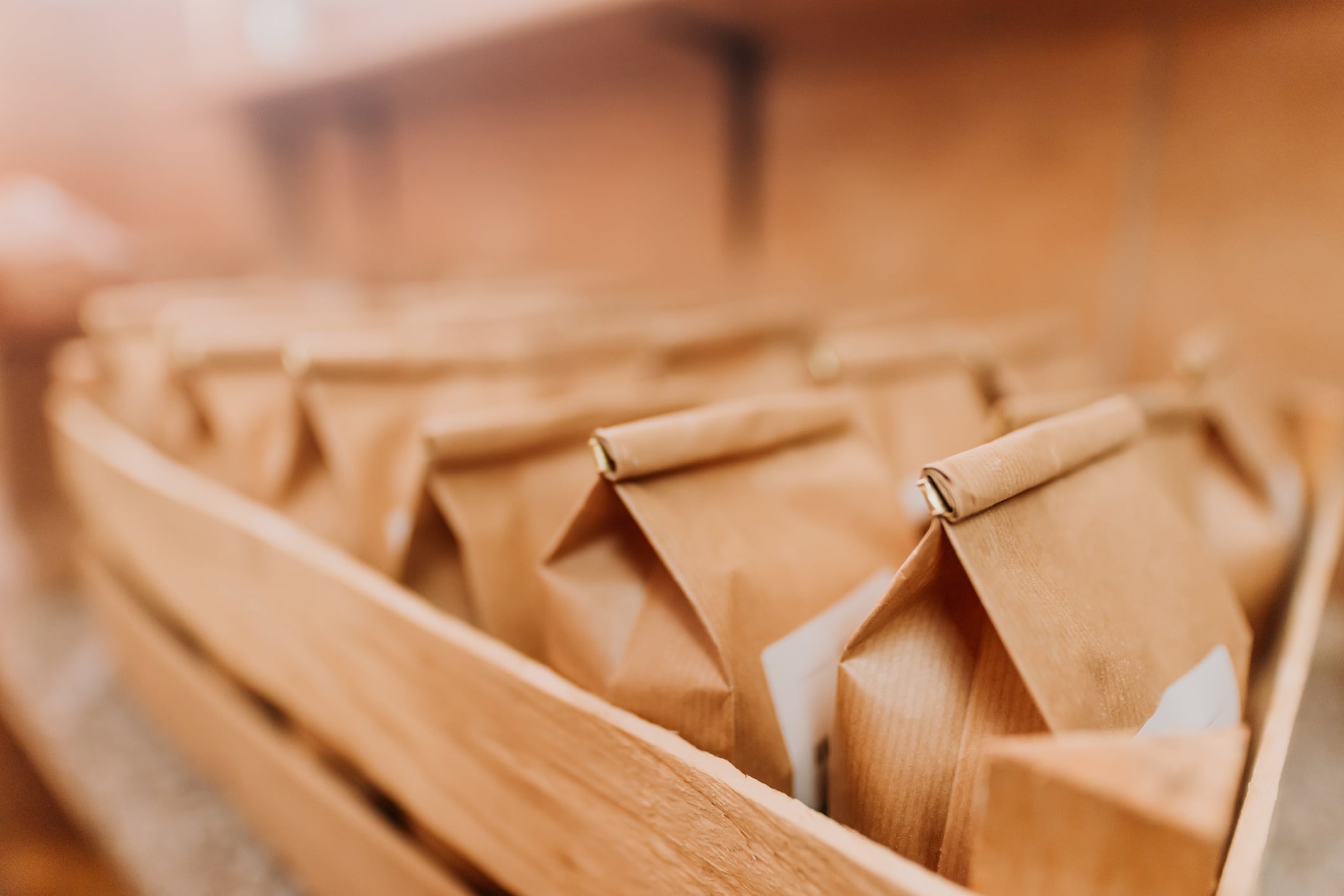 Row of flour paper bags in wooden crate