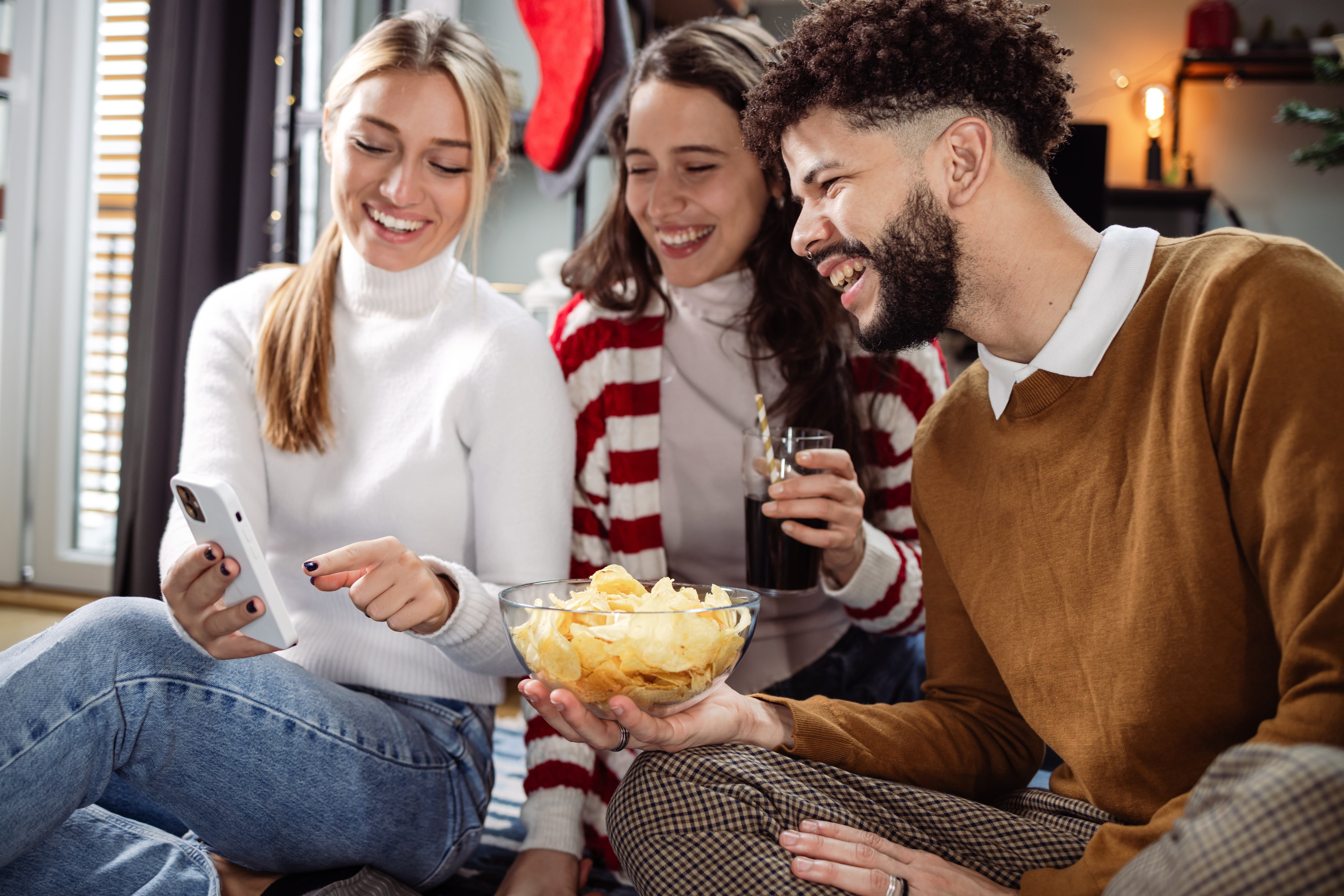 Group of friends eating snacks and looking at social media