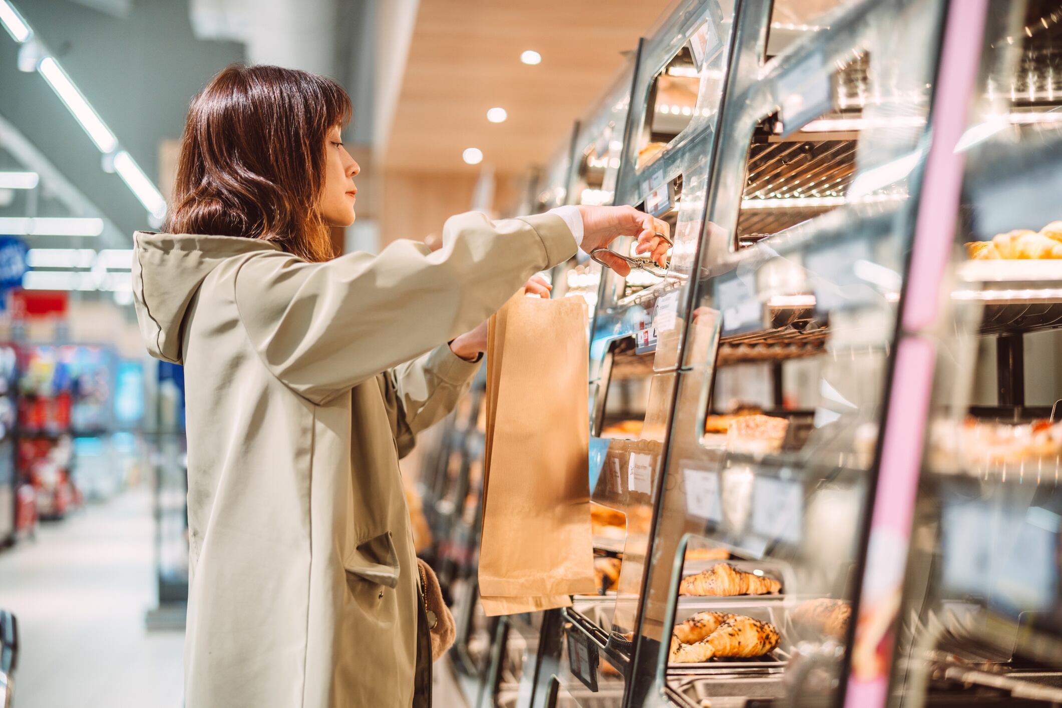 Woman choosing fresh bread at supermarket bakery Images By Tang Ming Tung GettyImages