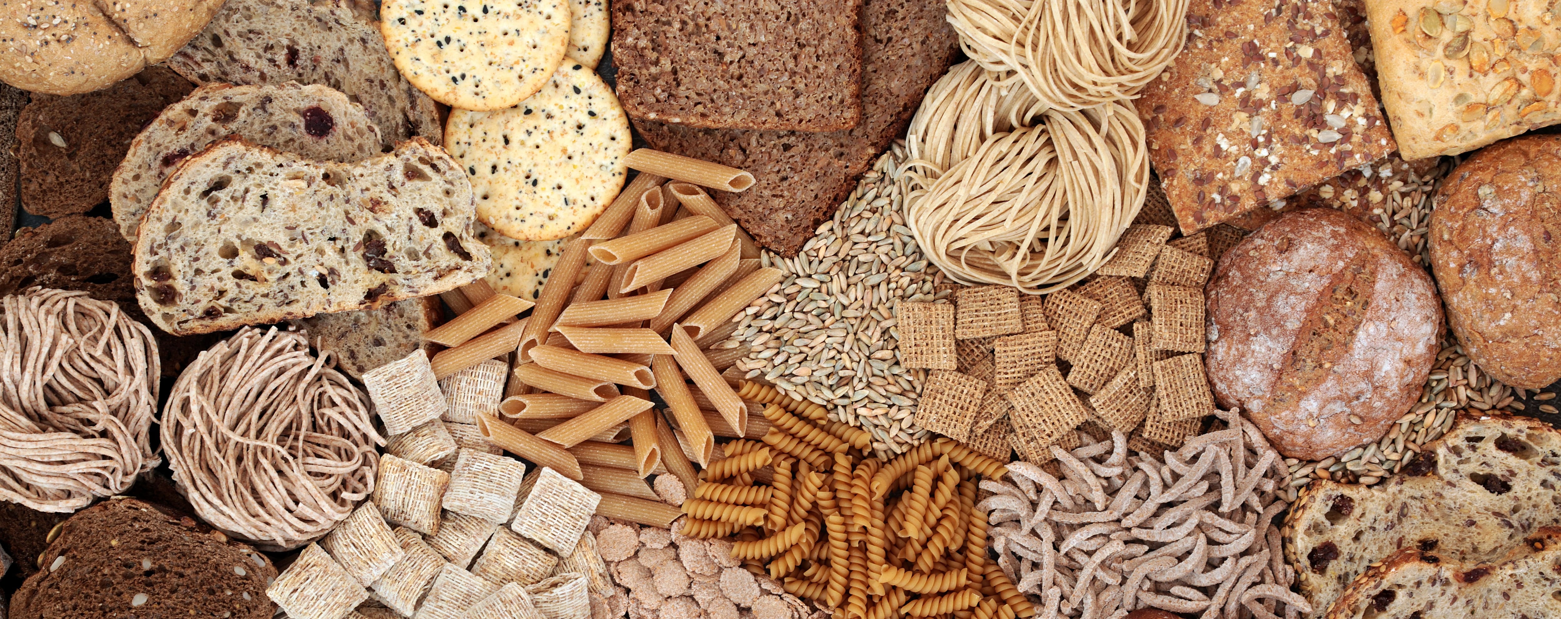 High fibre food for good health concept with pasta, bread, grains and cereals containing smart carbs, vitamins & antioxidants with low GI levels. Lowers blood pressure & cholesterol & optimises a healthy heart.