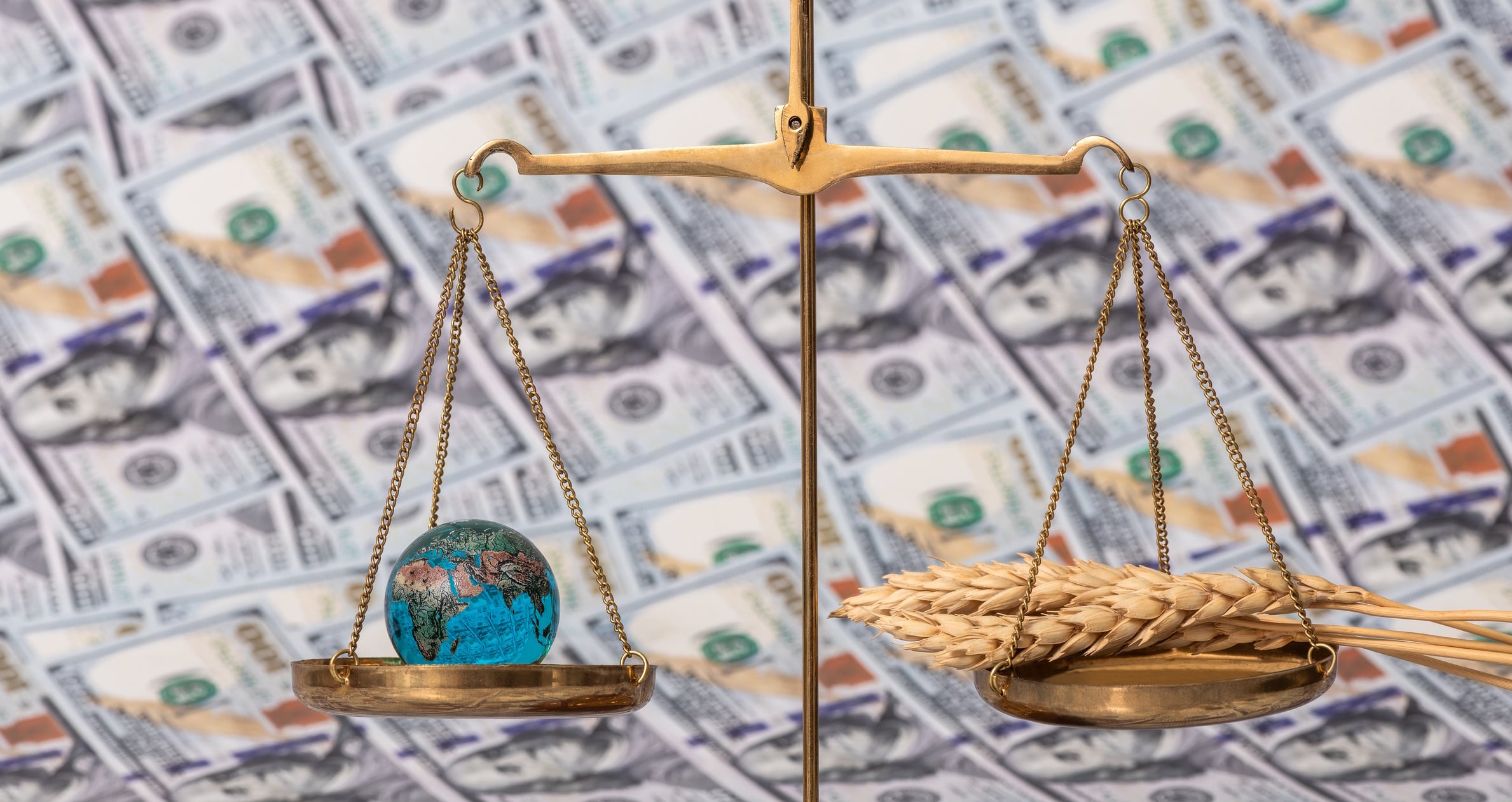 Conceptual story about the global food crisis with ears of wheat, a glass globe, scales and 100 american dollar bills Max Zolotukhin GettyImages