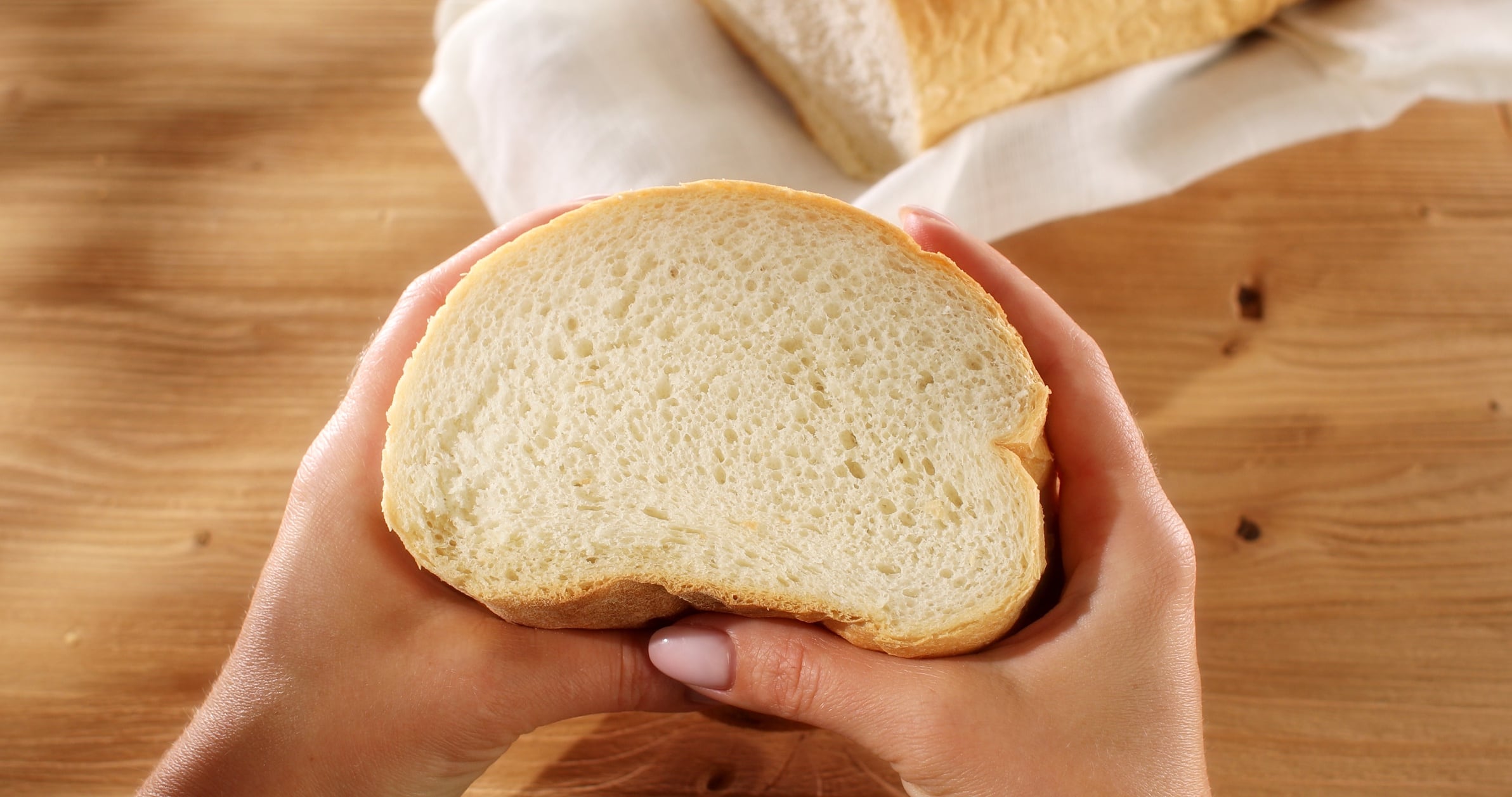 Female hands squeeze fresh bread. Check bread freshness.