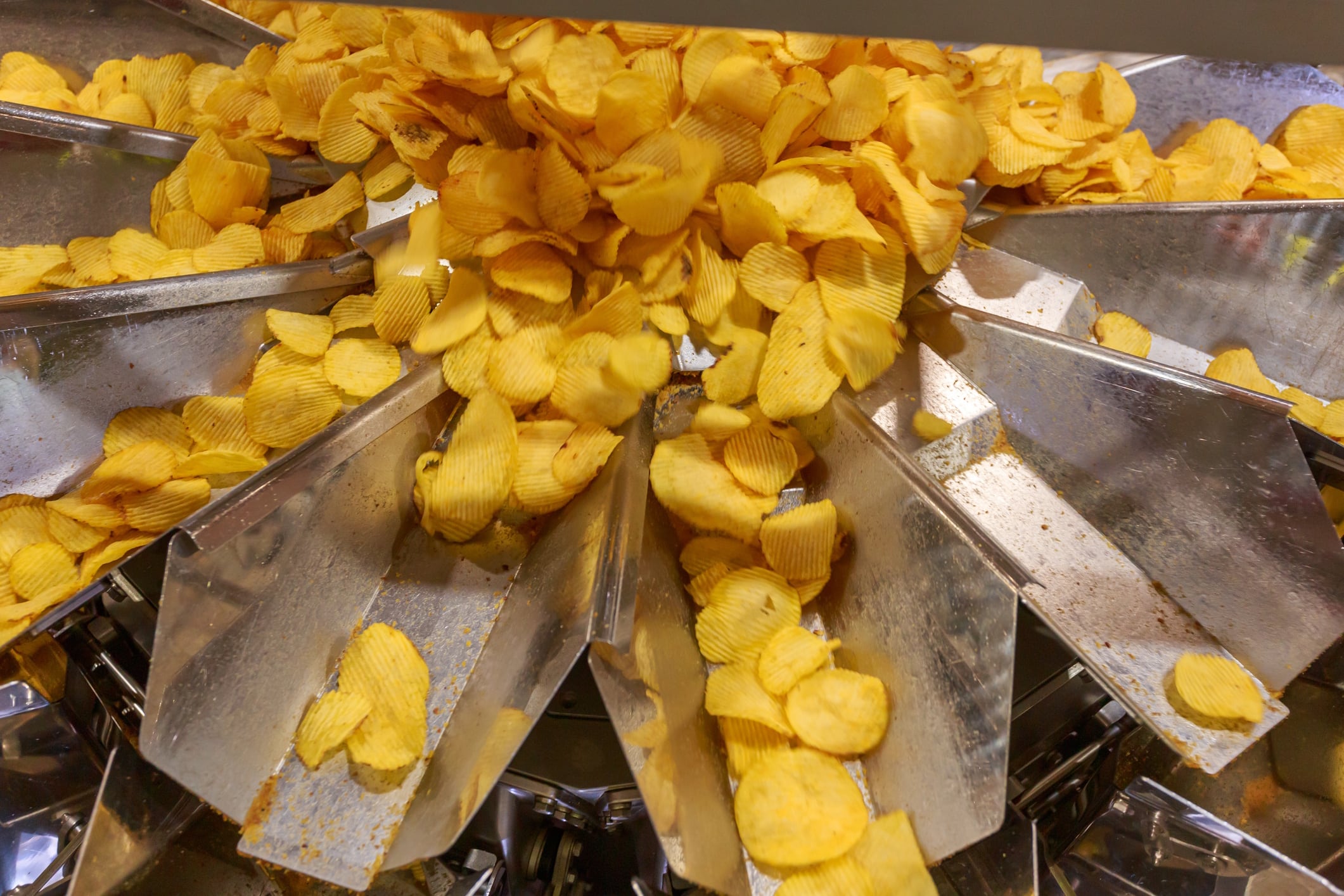 Special equipment of snacks producing facility. Bucket machine for measuring potato chips. Elena Bionysheva-Abramova GettyImages