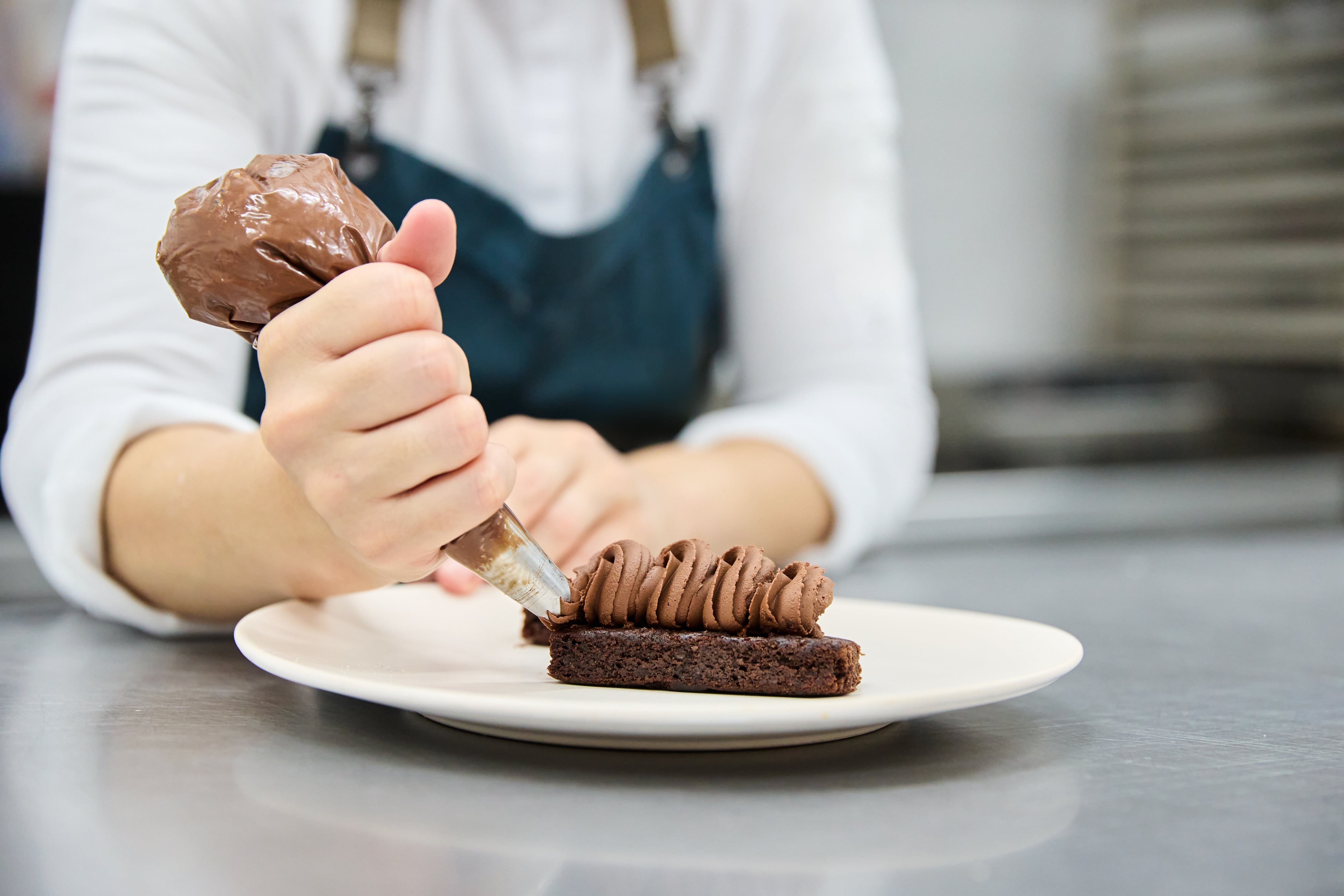 Female pastry chef decorating a pastry