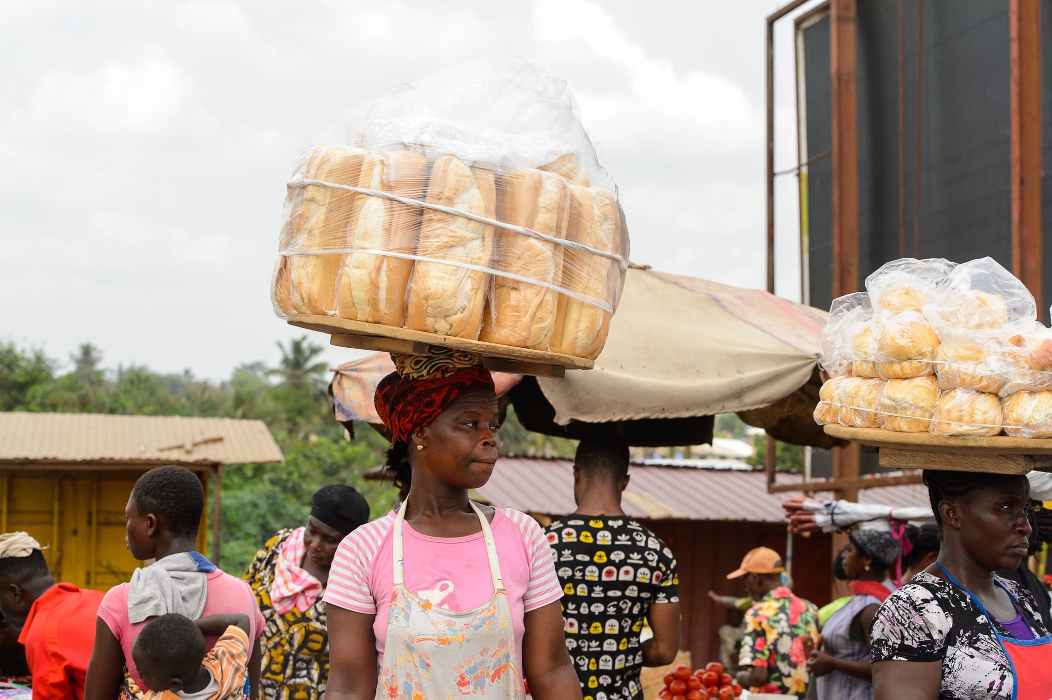 Ghanaian woman carries a tray with bread in local village Siempreverde22 GettyImages