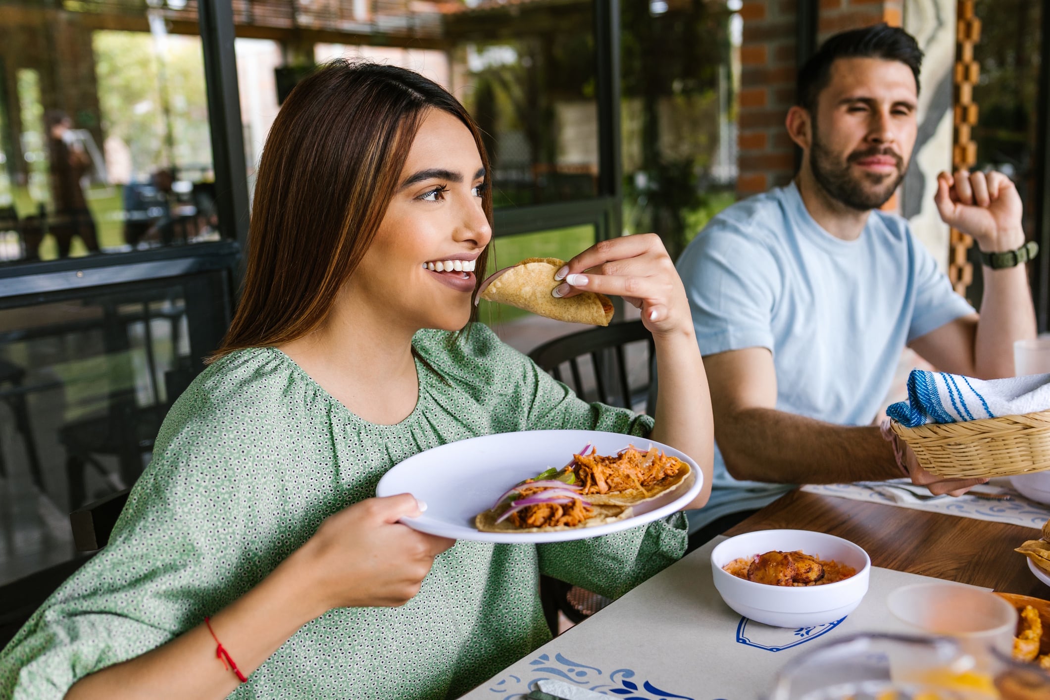 Young latin woman eating mexican tacos on a restaurant terrace in Mexico Latin America Marcos Elihu Castillo Ramirez GettyImages