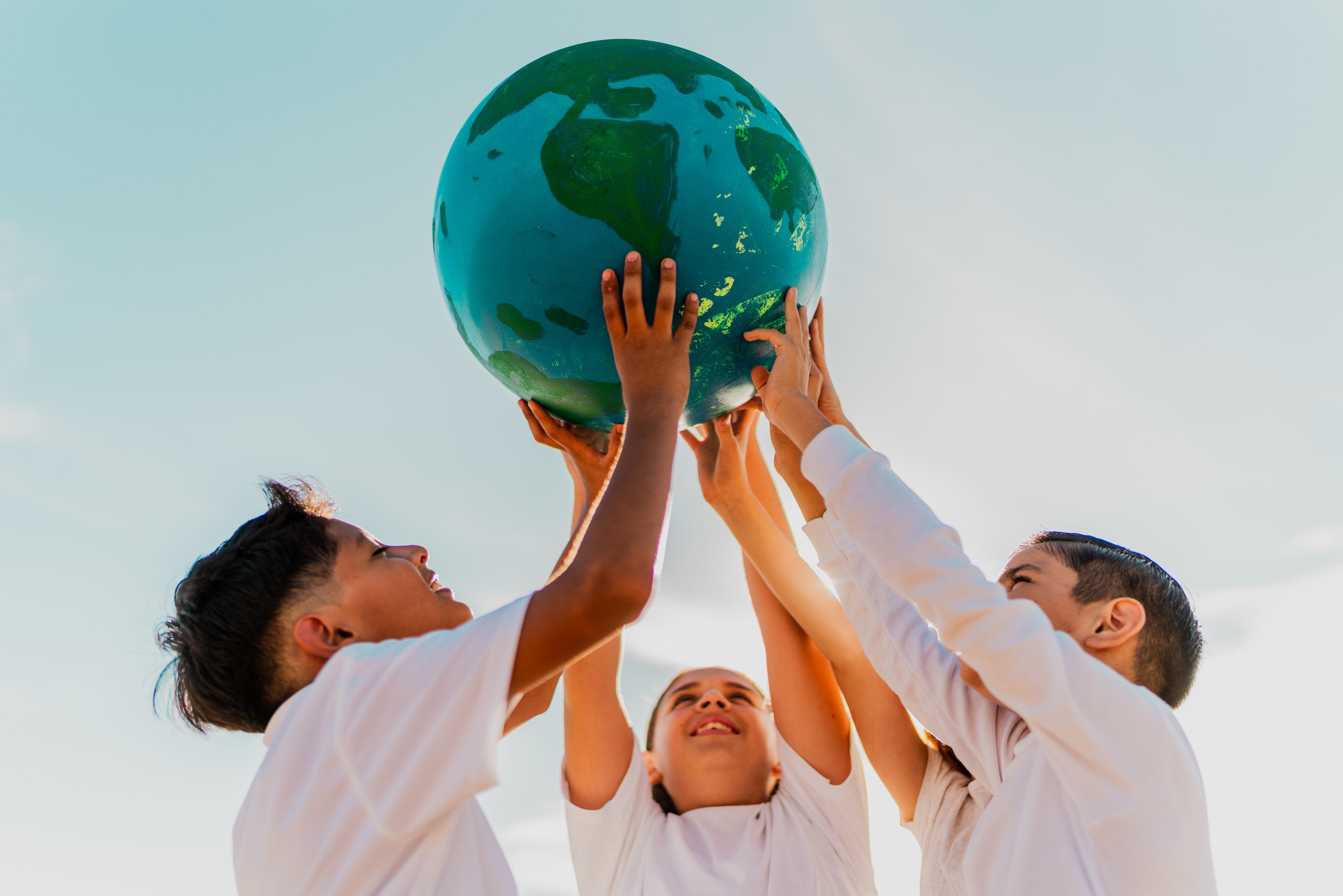 Children playing with a planet-themed beach ball
