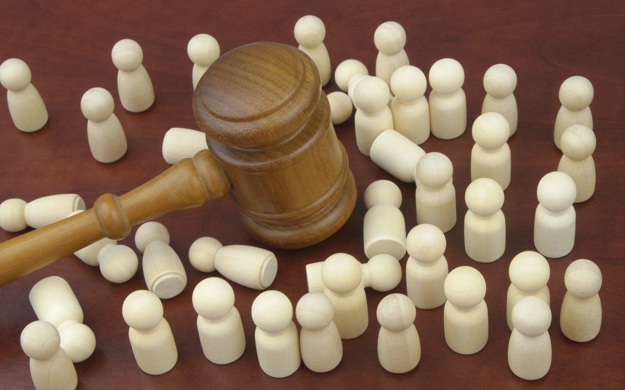 Judge gavel and many people figures, some figures laying on table. Valerii Evlakhov GettyImages