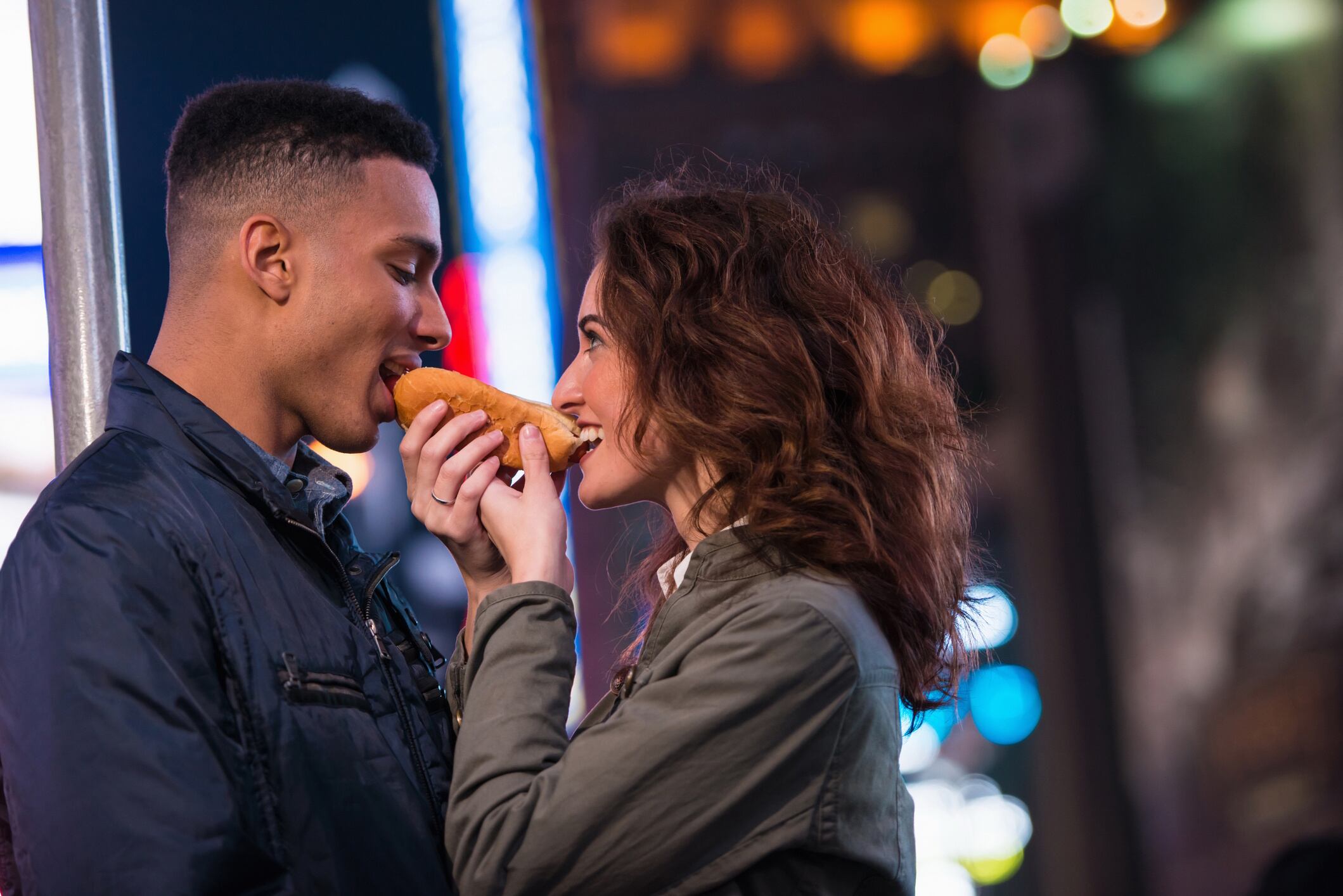Young tourist couple sharing hotdog, New York City, USA Florin Prunoiu-GettyImages
