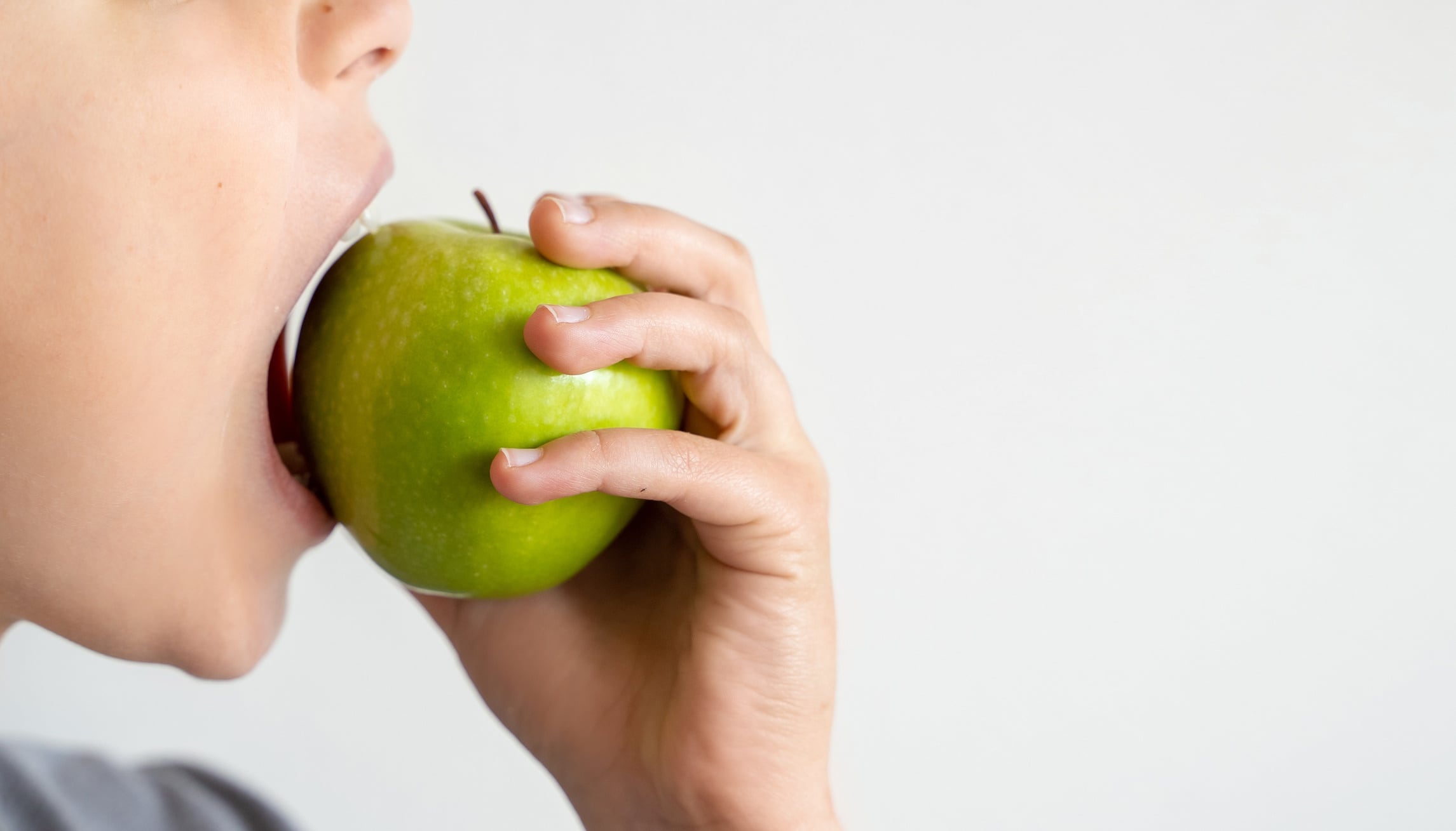 Close up of child eating an apple