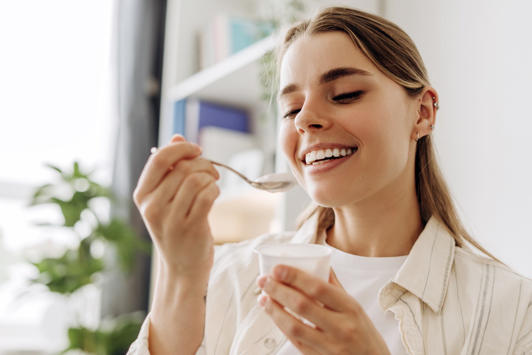 Young woman enjoying a healthy yogurt snack, promoting wellness and healthy eating habits. Food concept