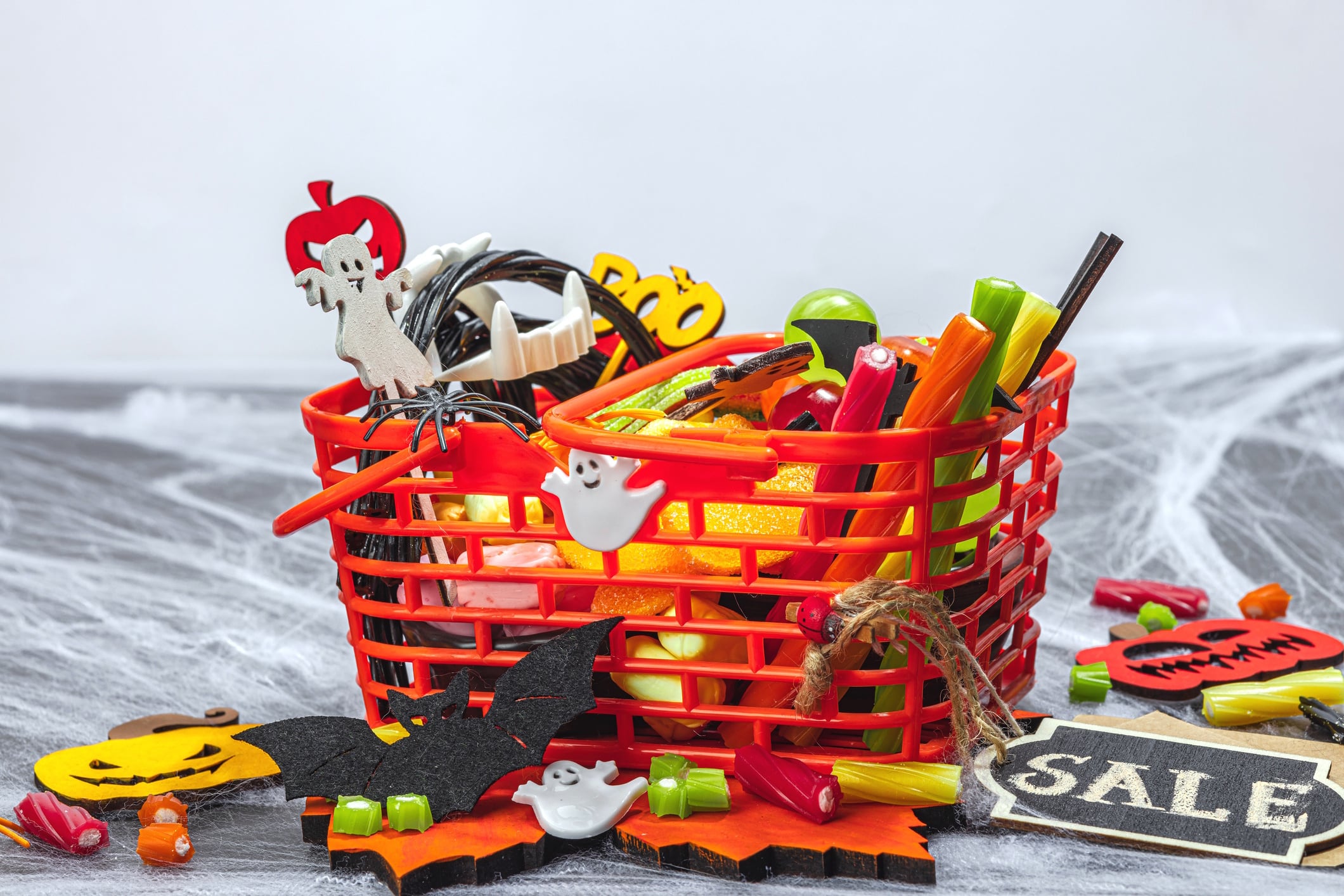 Full of sweets basket, sale concept. Funny Halloween background. Scary spider web Fuzullhanum GettyImages