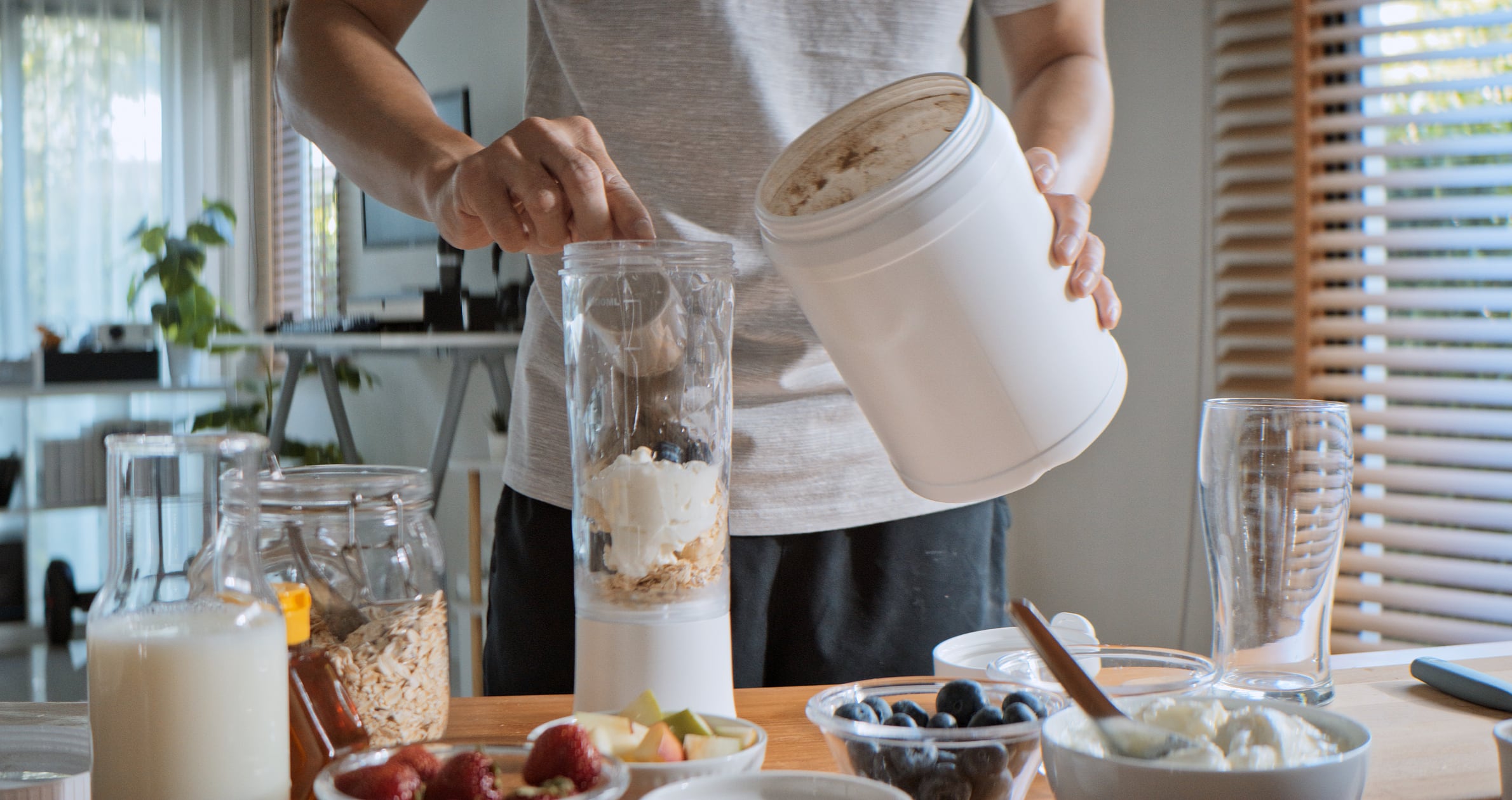 Young adult Asian man prepare and make protein shake drink, mixed fruit cereal juice, using blender mixer. Fitness dietary activity, healthy diet lifestyle, health care nutrition concept