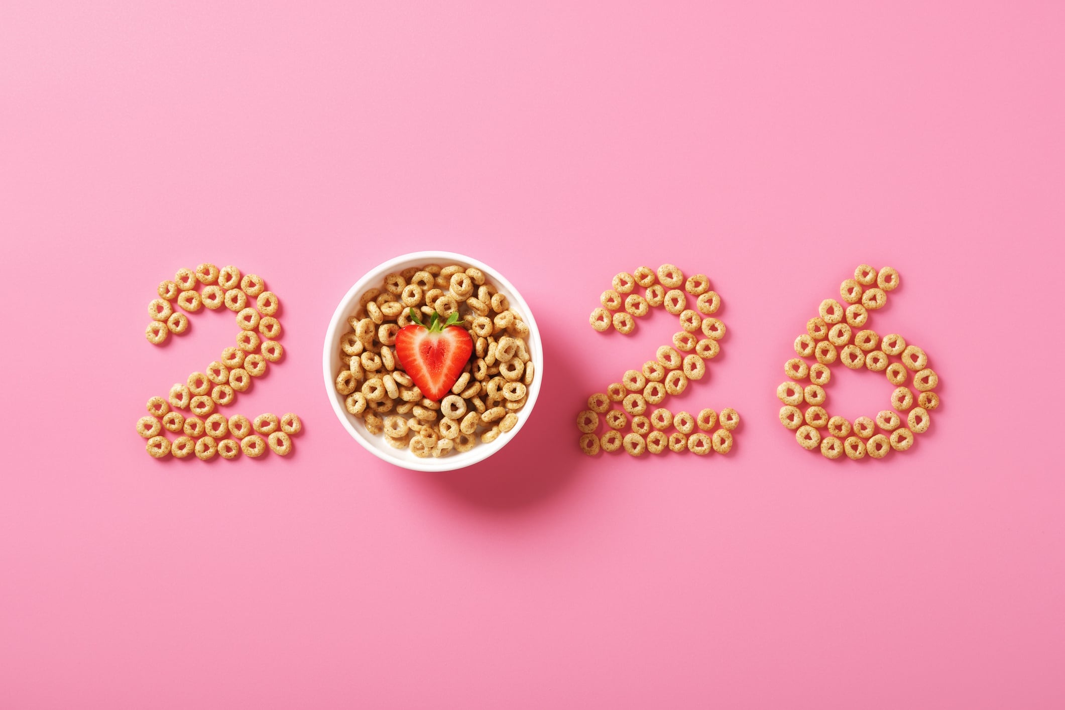 Numbers 2026 made from cereal rings on pink background.