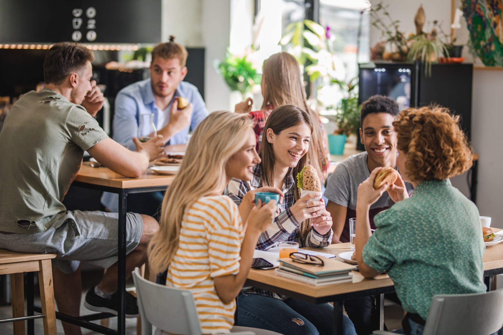 Happy group of Gen Zs during lunch break in cafeteria