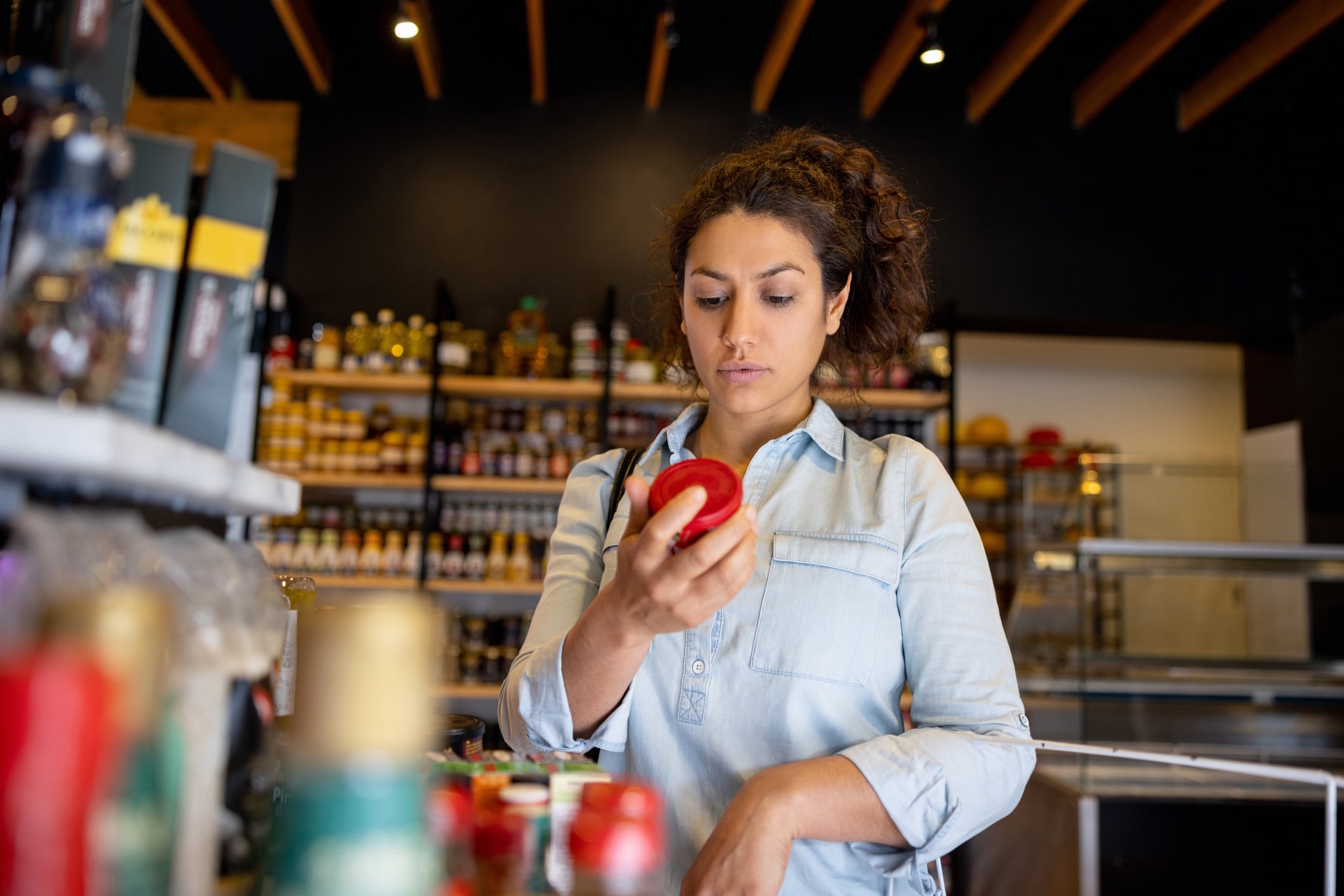 Woman shopping at the supermarket and reading the label on a product Hispanolistic GettyImages