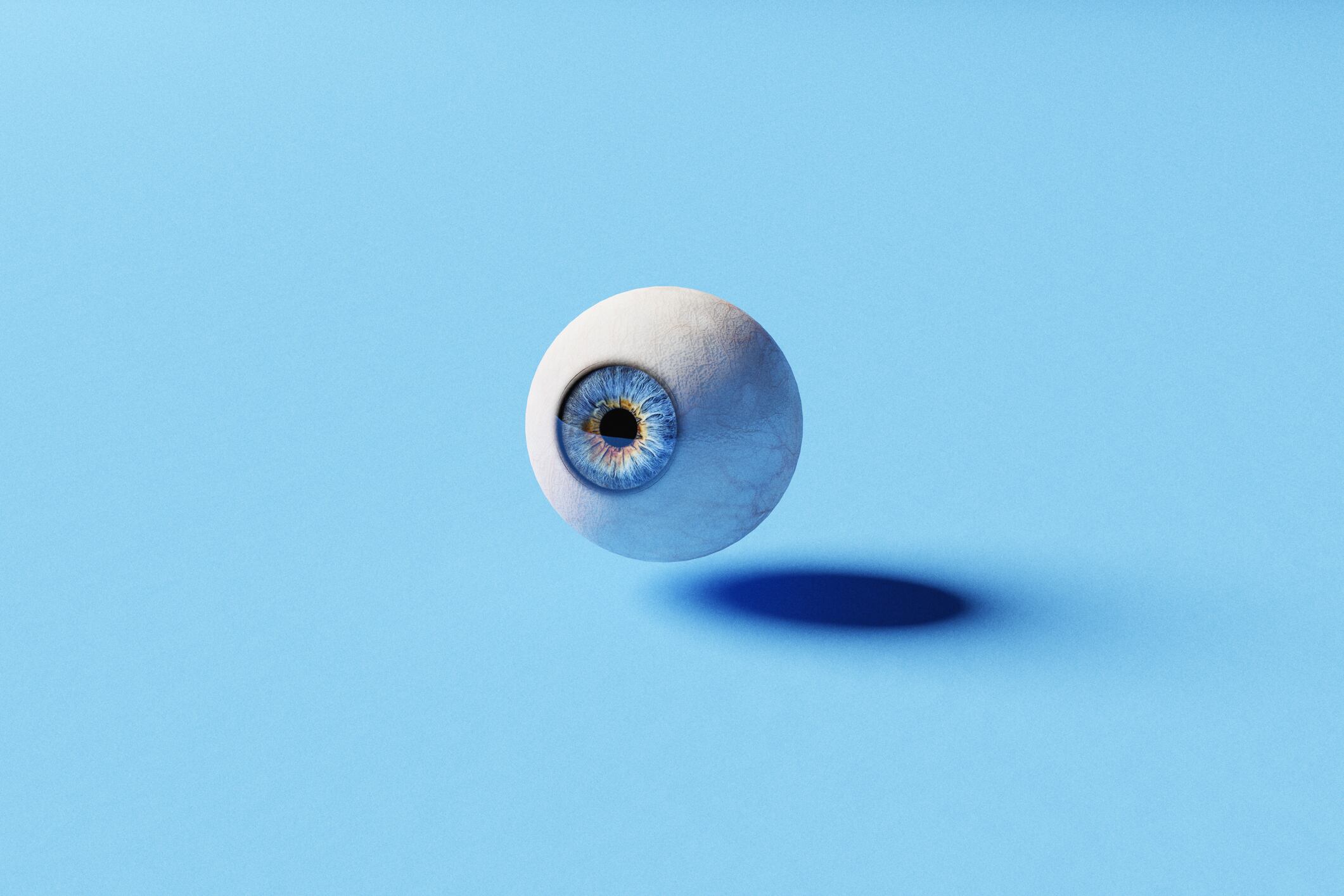 Single blue eye ball floating on a blue background