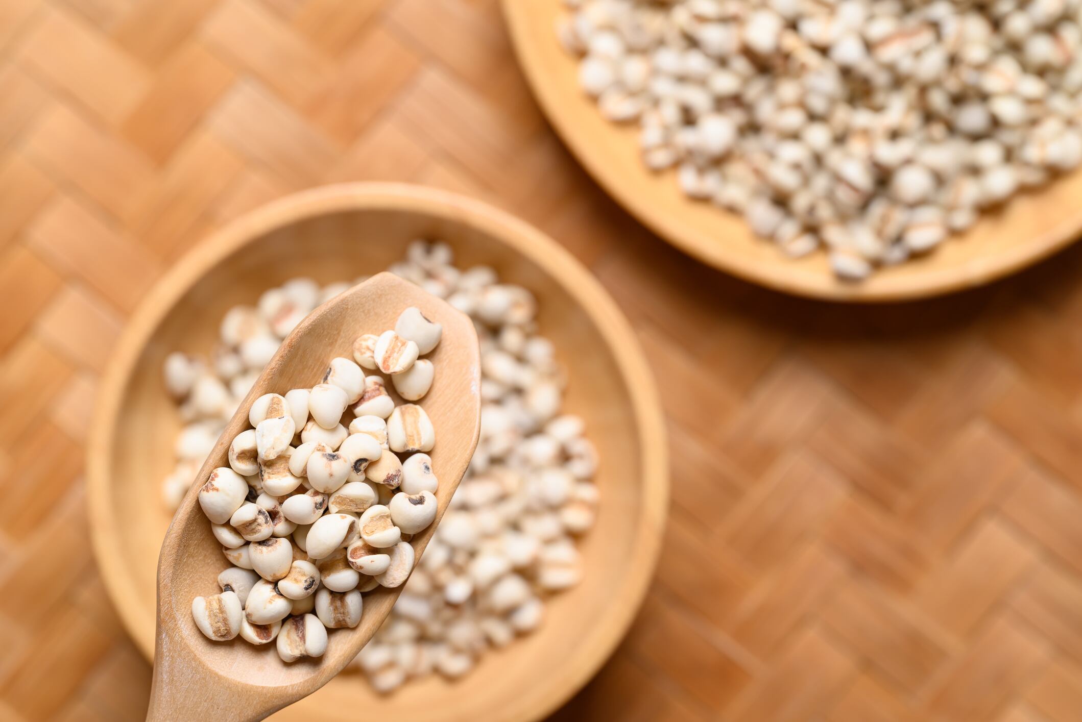 Dried Job's tears or adlay millet seeds in wooden scoop with bowl, Food ingredient, Top view