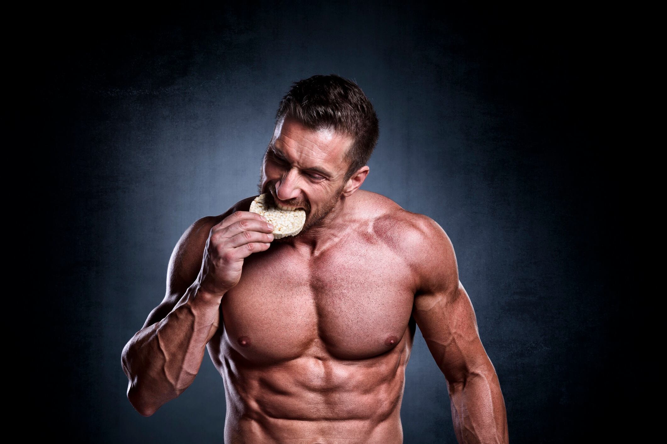 Male fitness fanatic eating rice cake