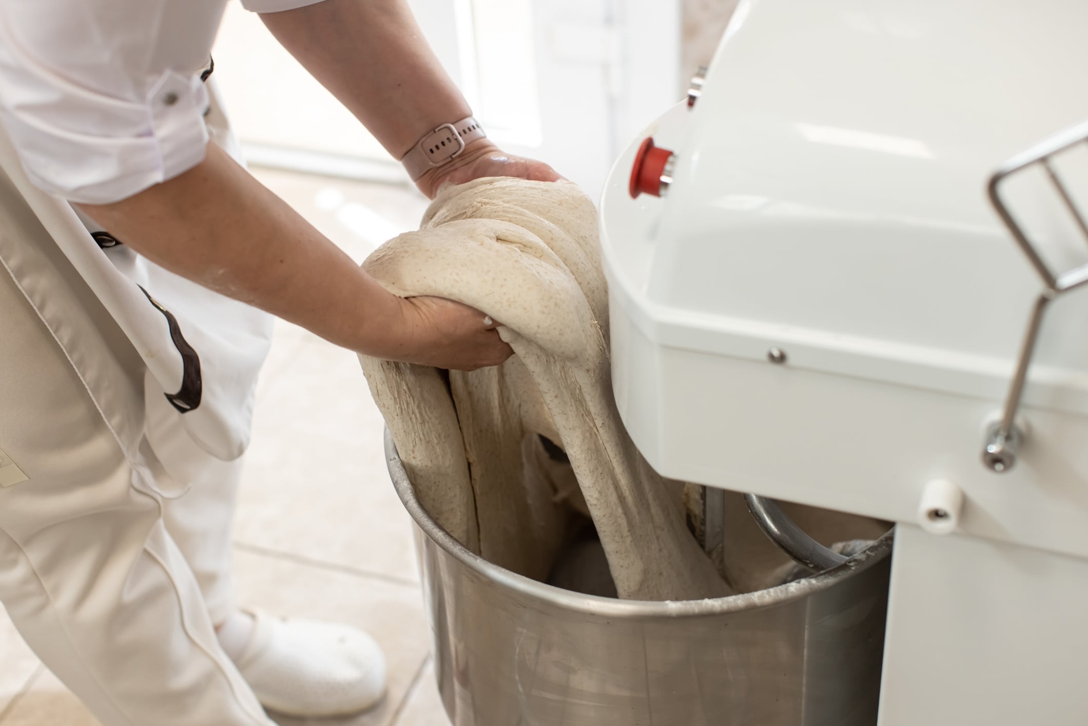 Baker taking dough out of a mixer