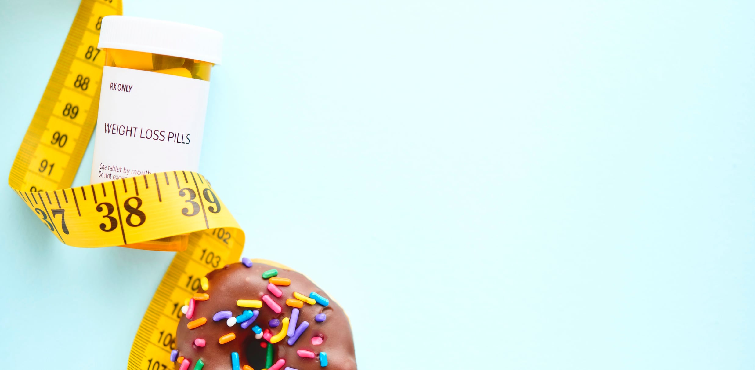 A donut with weight loss medication and a tape measure