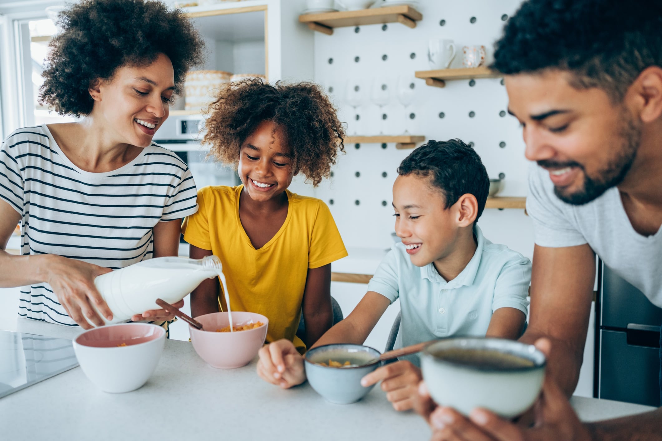 Happy family eating breakfast cereal