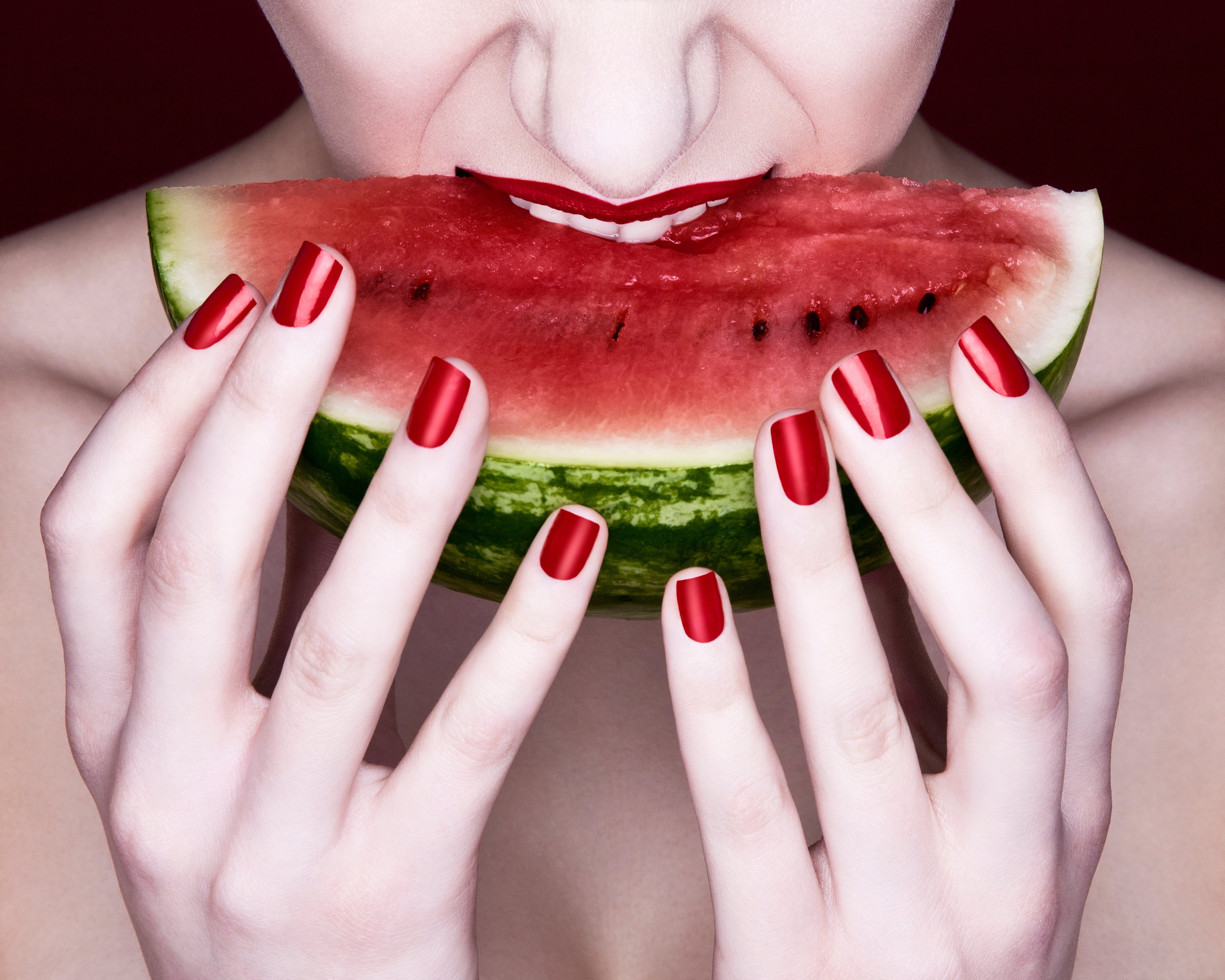 Woman biting into watermelon