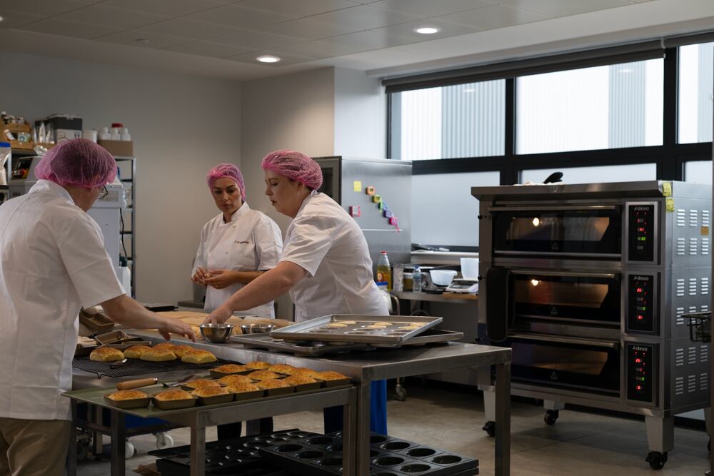 Three bakers in kitchen.