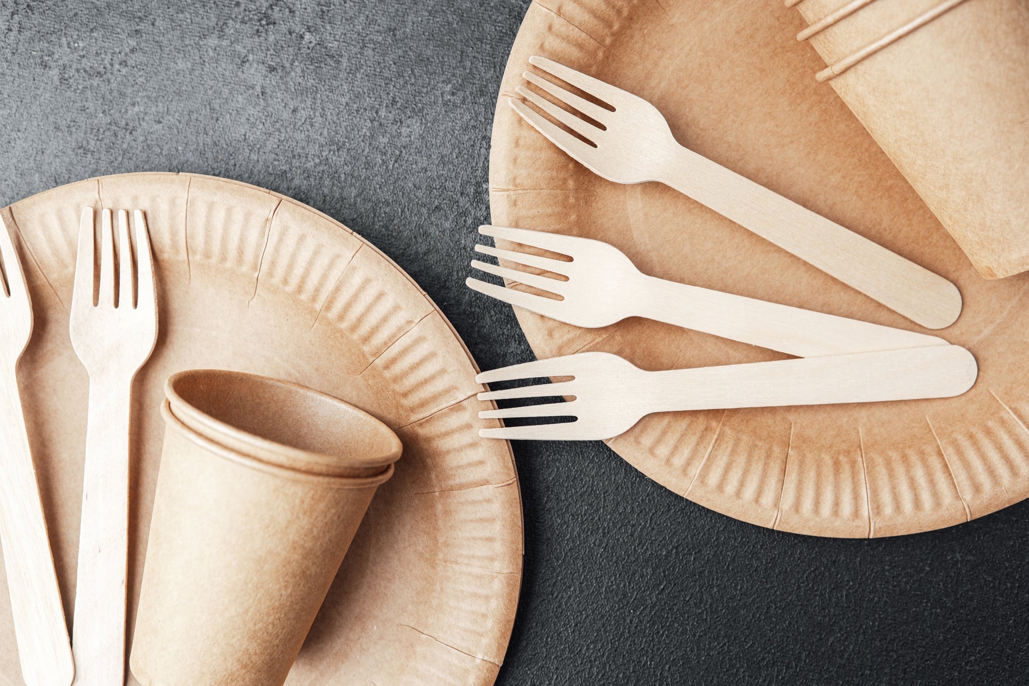 Two paper plates with forks and cups