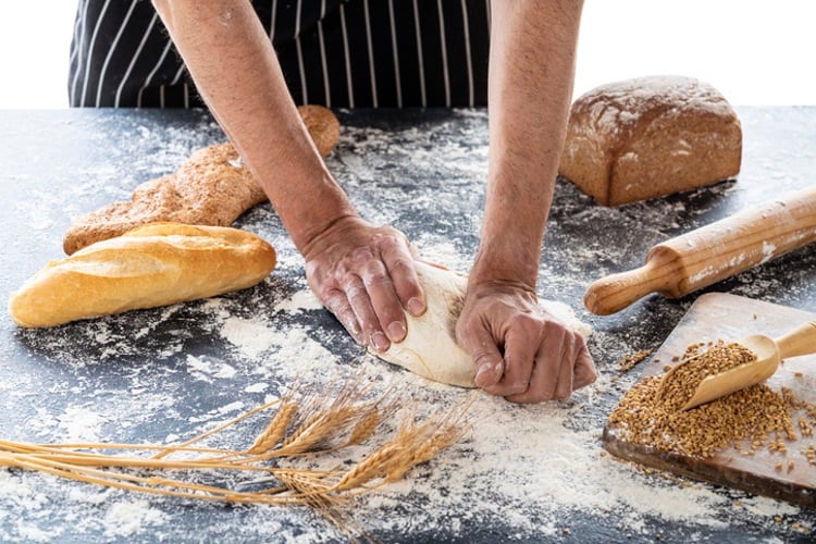 Baker kneading dough, ancient grains, wheat