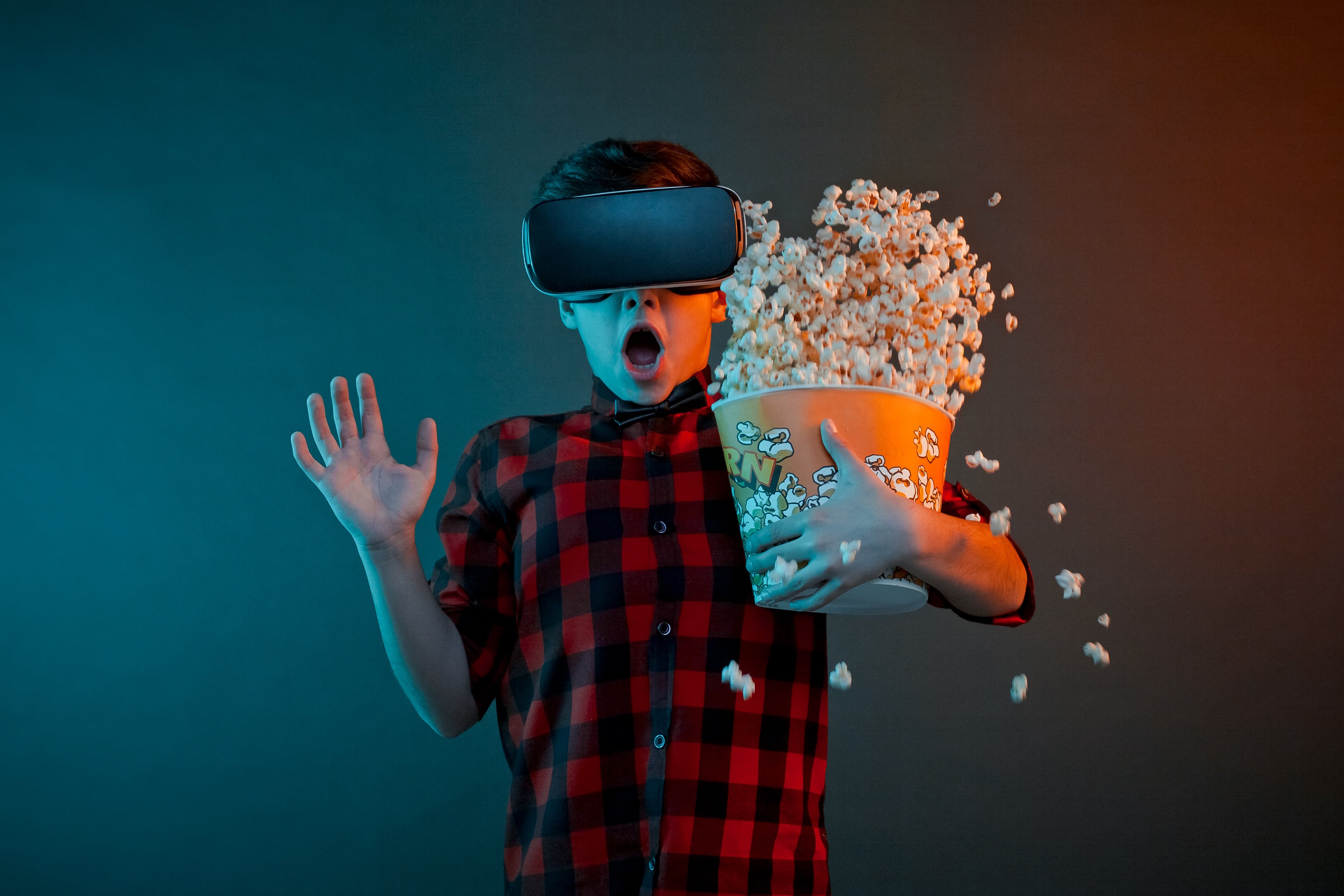 Scared boy with popcorn in VR headset
