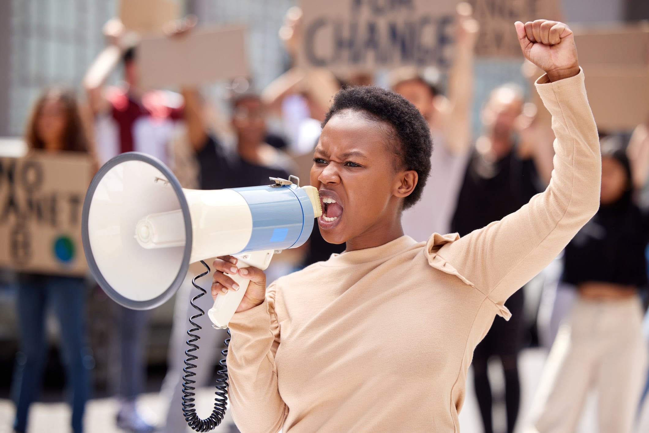 Young woman boycotting, shouting into loud hailer