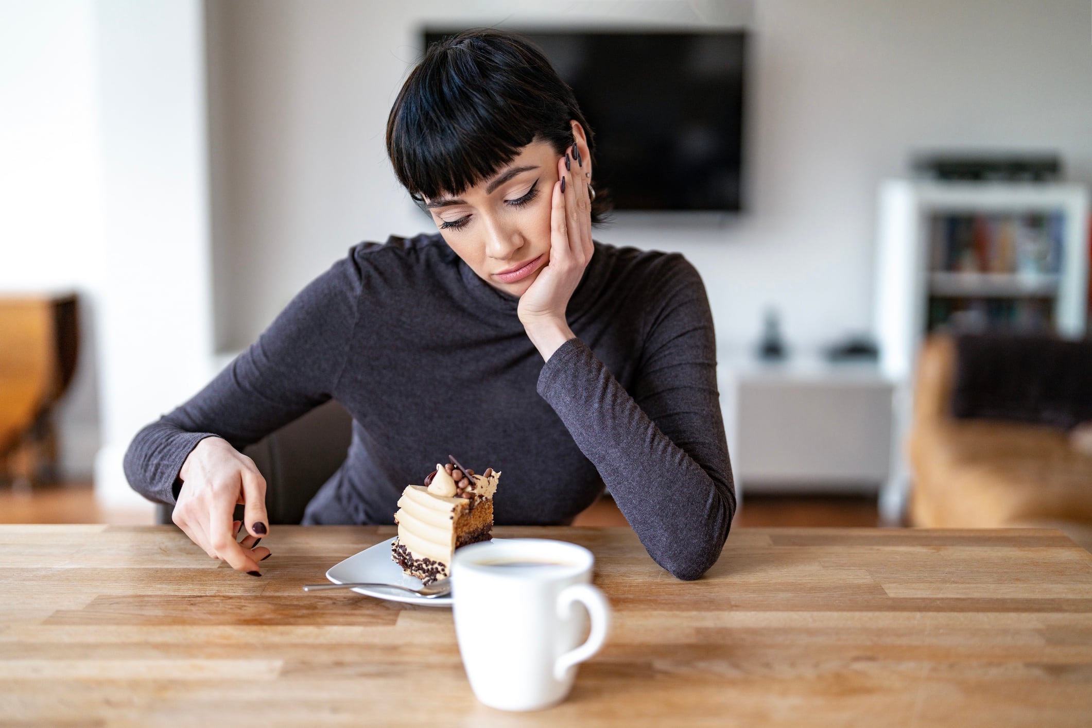 Woman contemplating chocolate cake