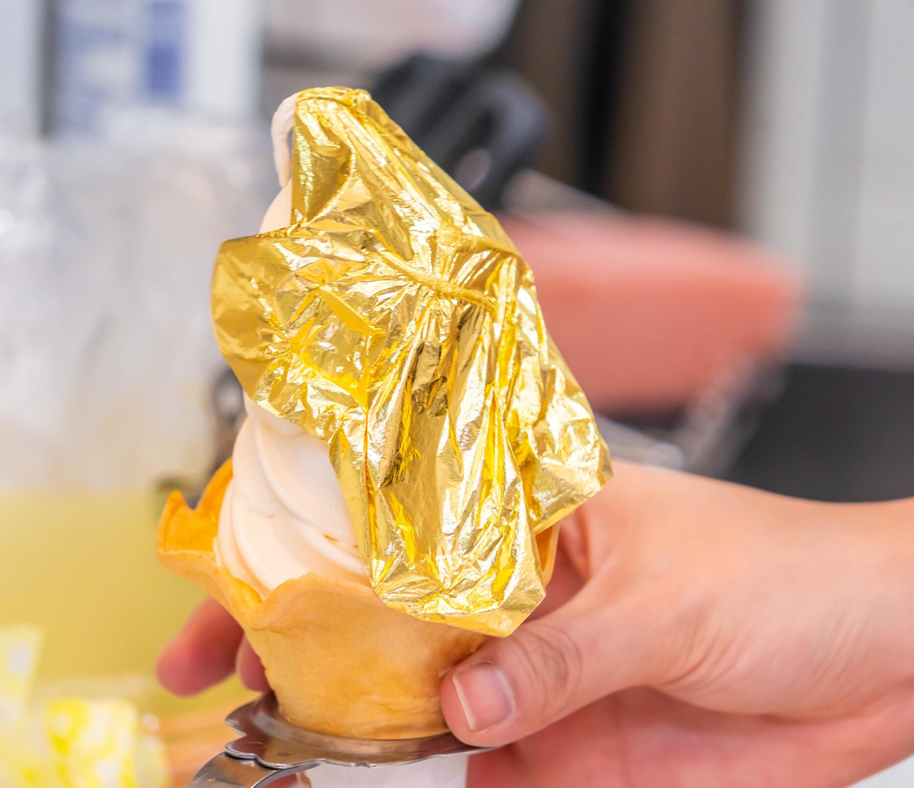 Hand is holding a golden leaf ice cream the signature ice cream of Kanazawa, Japan