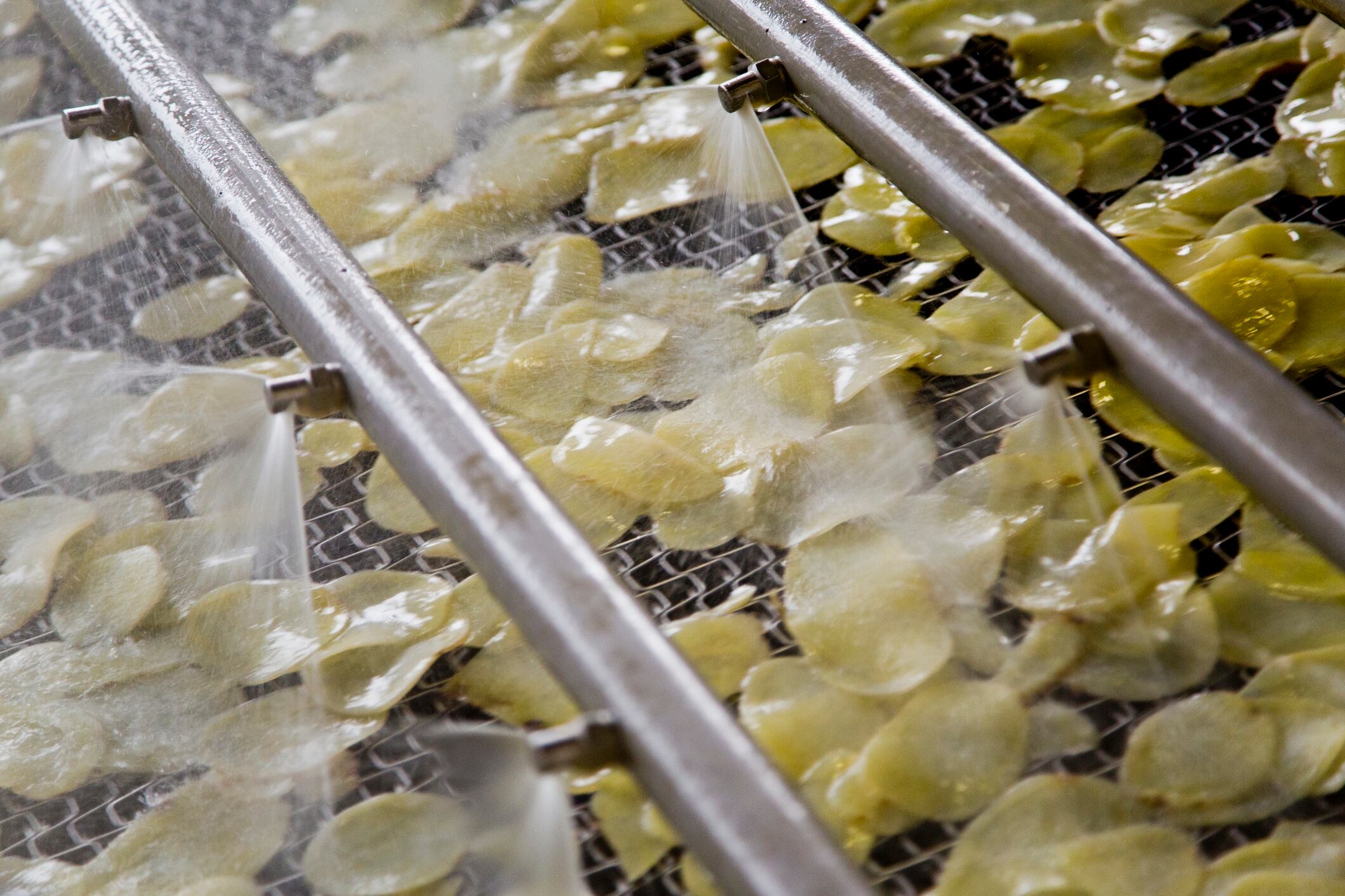 High Angle View Of Water Spraying On Potato In Machine - stock photo