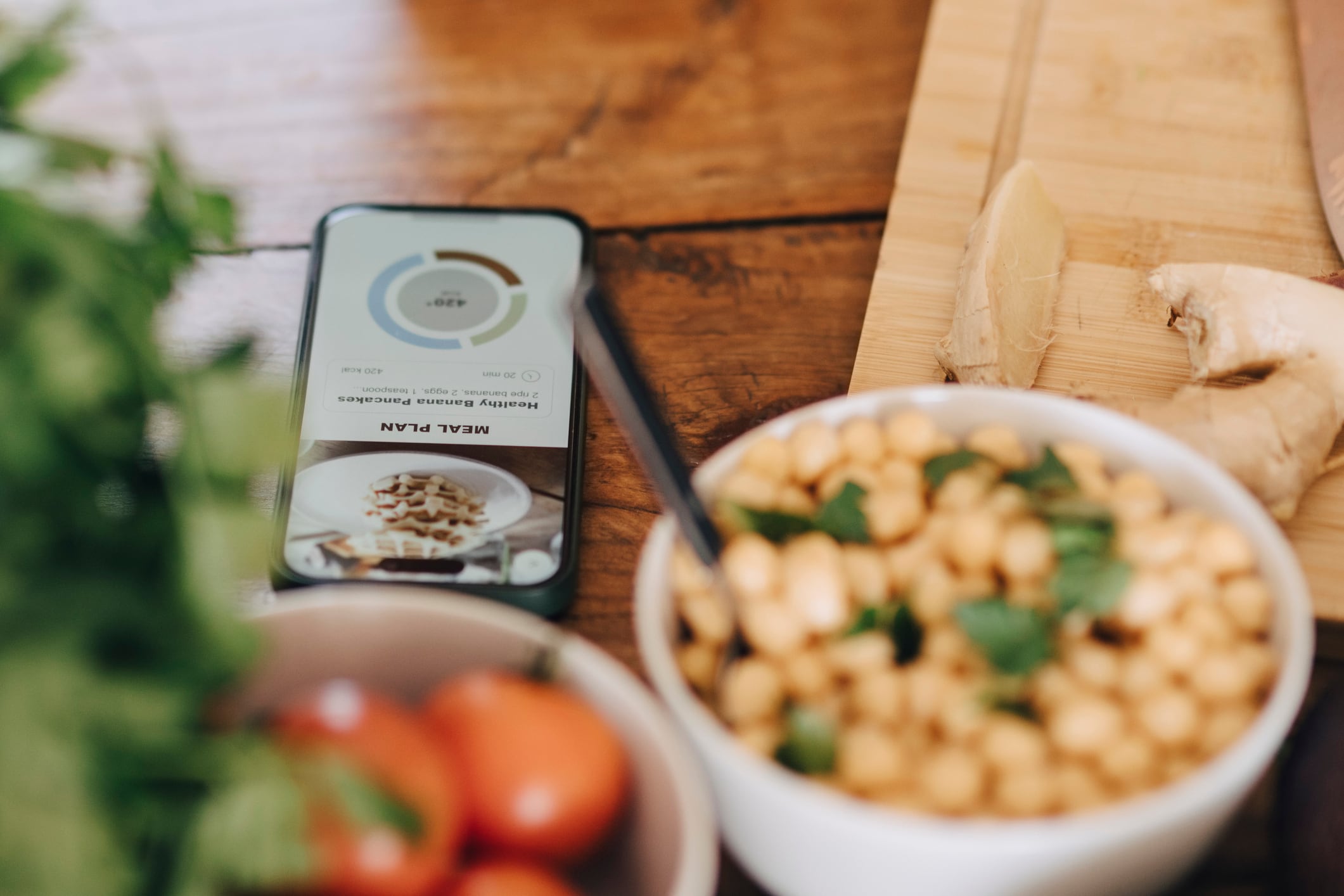 Smart phone with meal plan by bowl on dining table