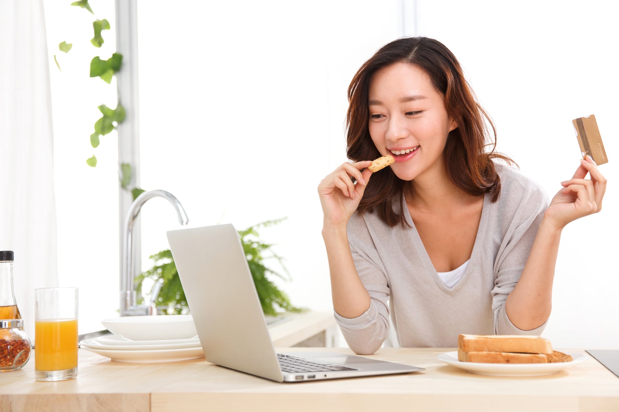 Young Chinese woman eating bread and biscuits GettyImages