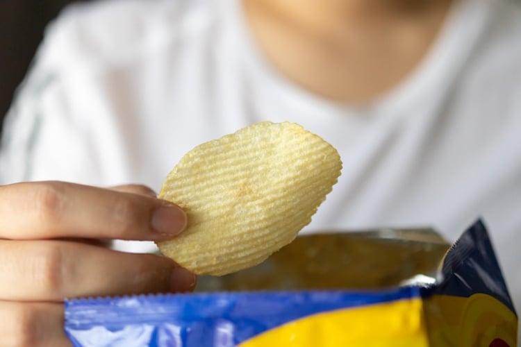 Hand-holding-a-potato-chip-GettyImages-1345227334.jpg