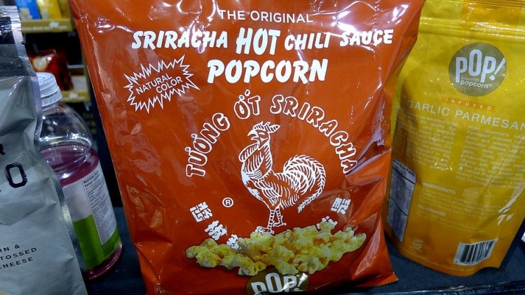 Pop Gourmet goes big with its co-branded Sriracha Popcorn by blazing the hot sauce's bottle imagery across the entire front.