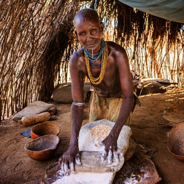 An ethiopian woman making sorghum flour Getty